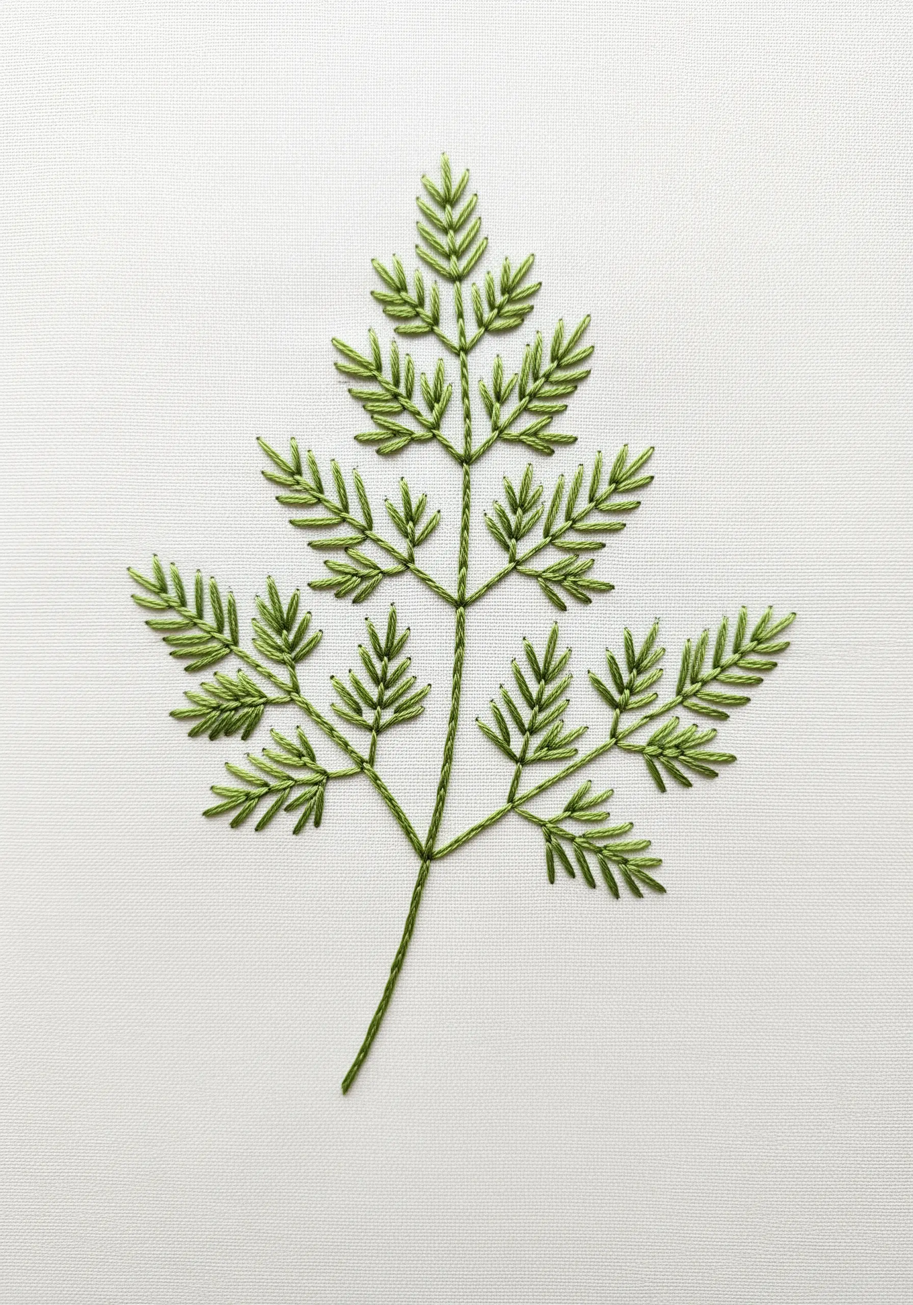A fern-like parsley leaf embroidered with precise, geometric straight stitches on white fabric.
