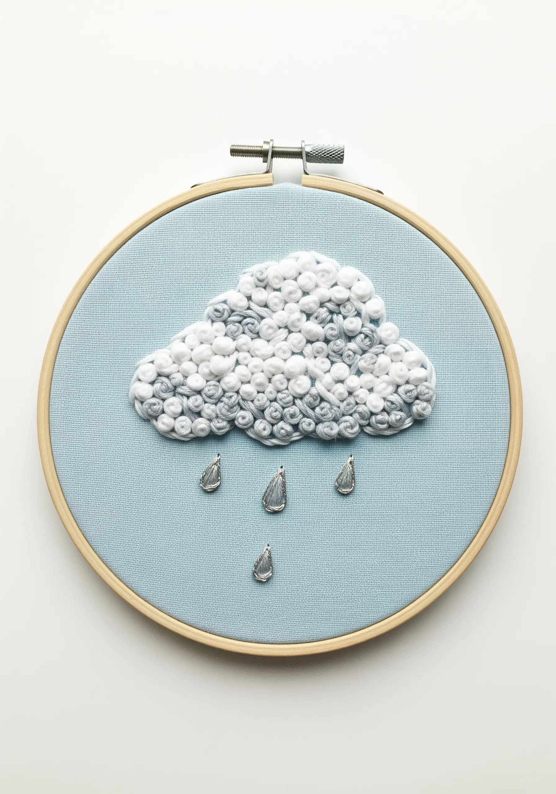 Textured cloud made of white and grey French knots with metallic silver raindrops.