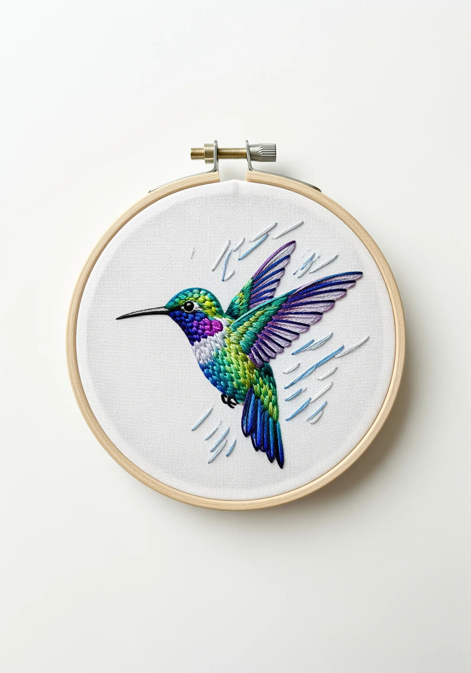 An iridescent embroidered hummingbird in a hoop, stitched with shiny threads.
