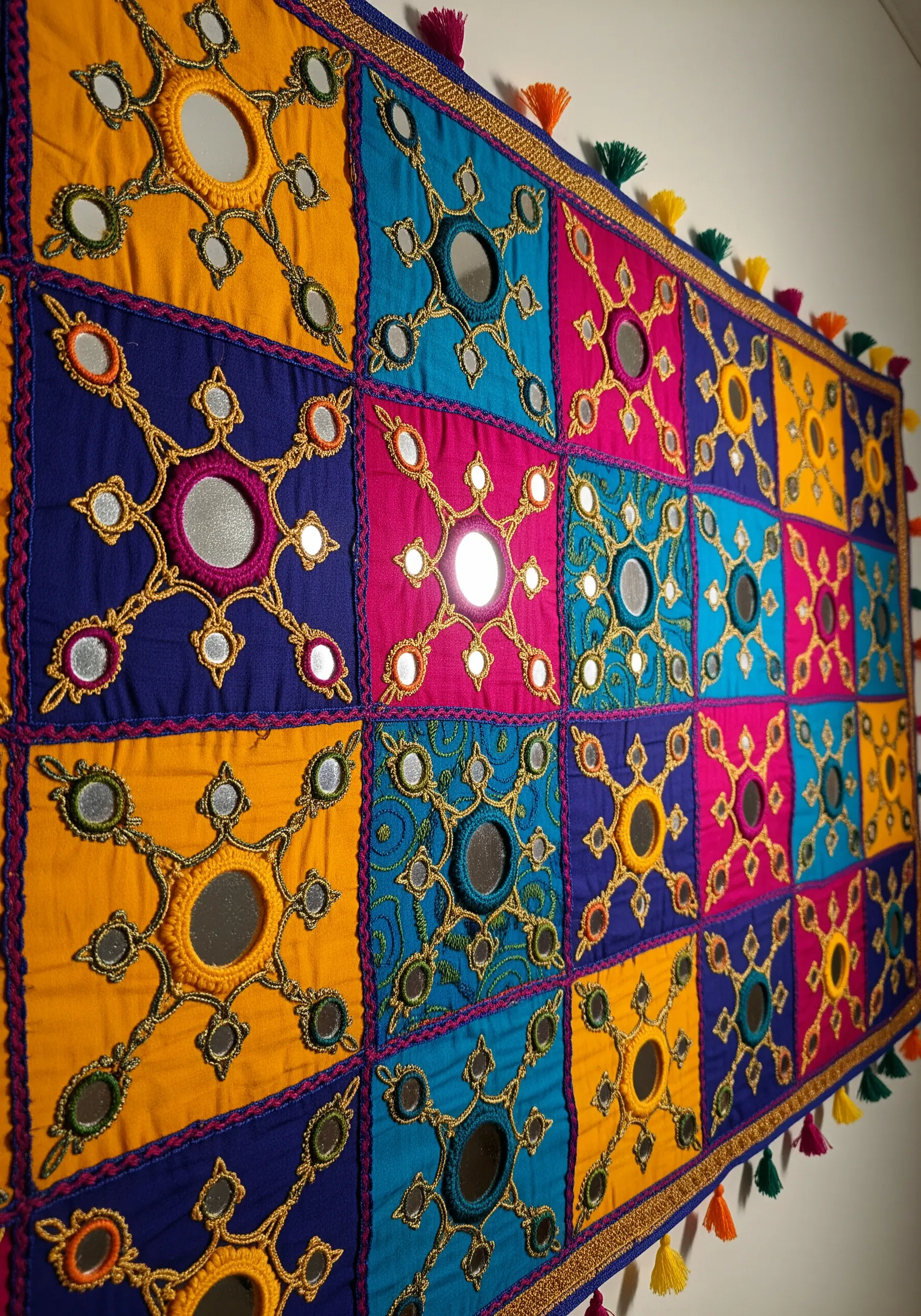A colorful patchwork textile with intricate Shisha mirror work and embroidery.