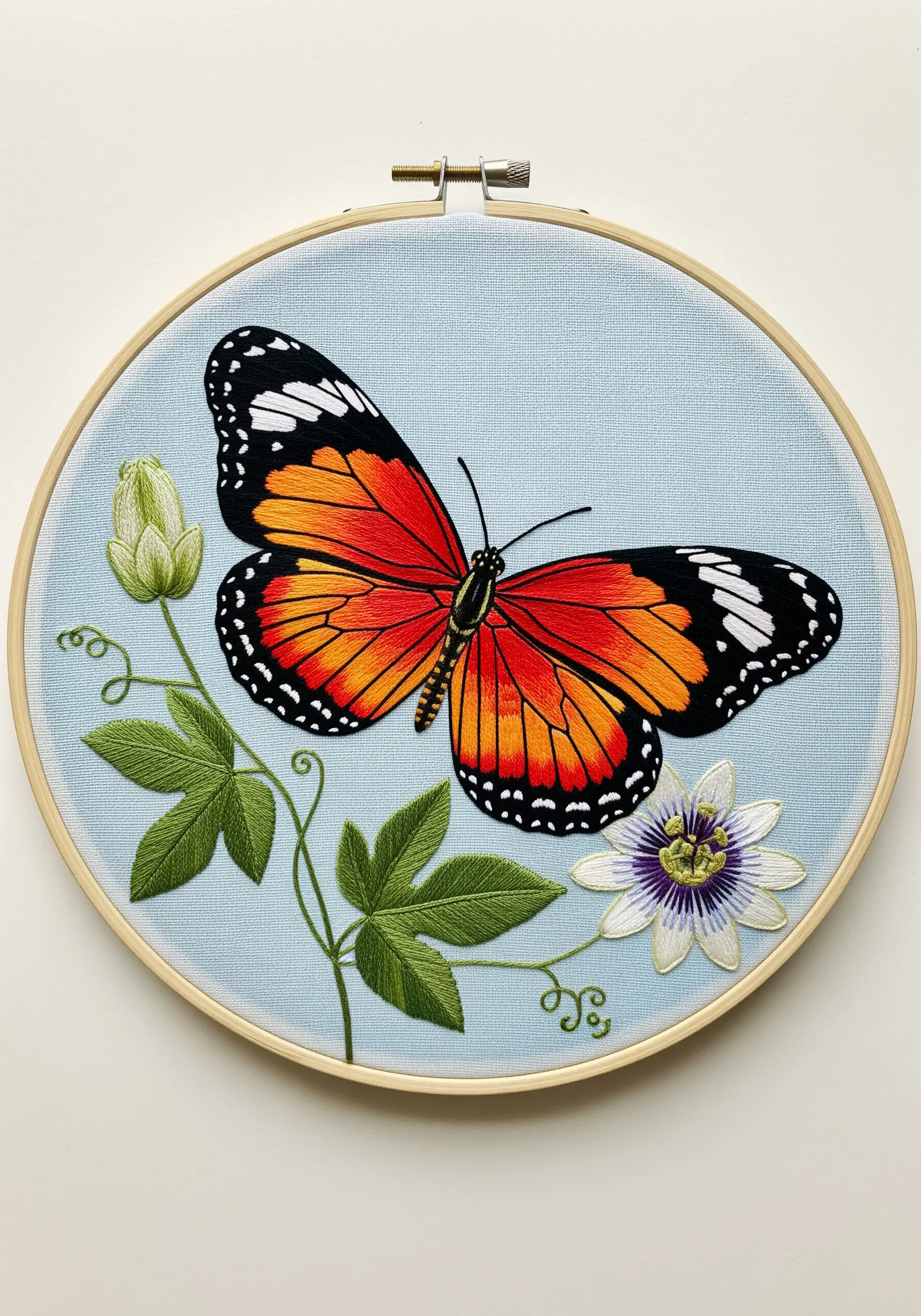 An orange and black Common Tiger butterfly embroidered next to a passionflower.