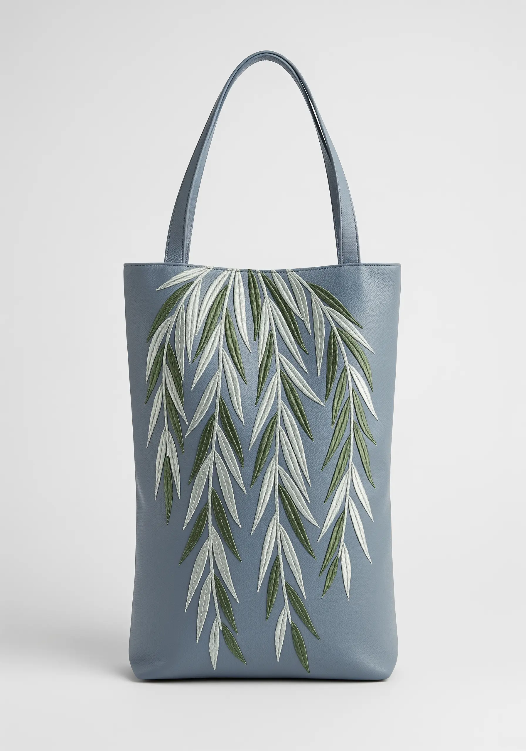 Appliquéd and embroidered weeping willow leaves in green and white on a blue-grey bag.