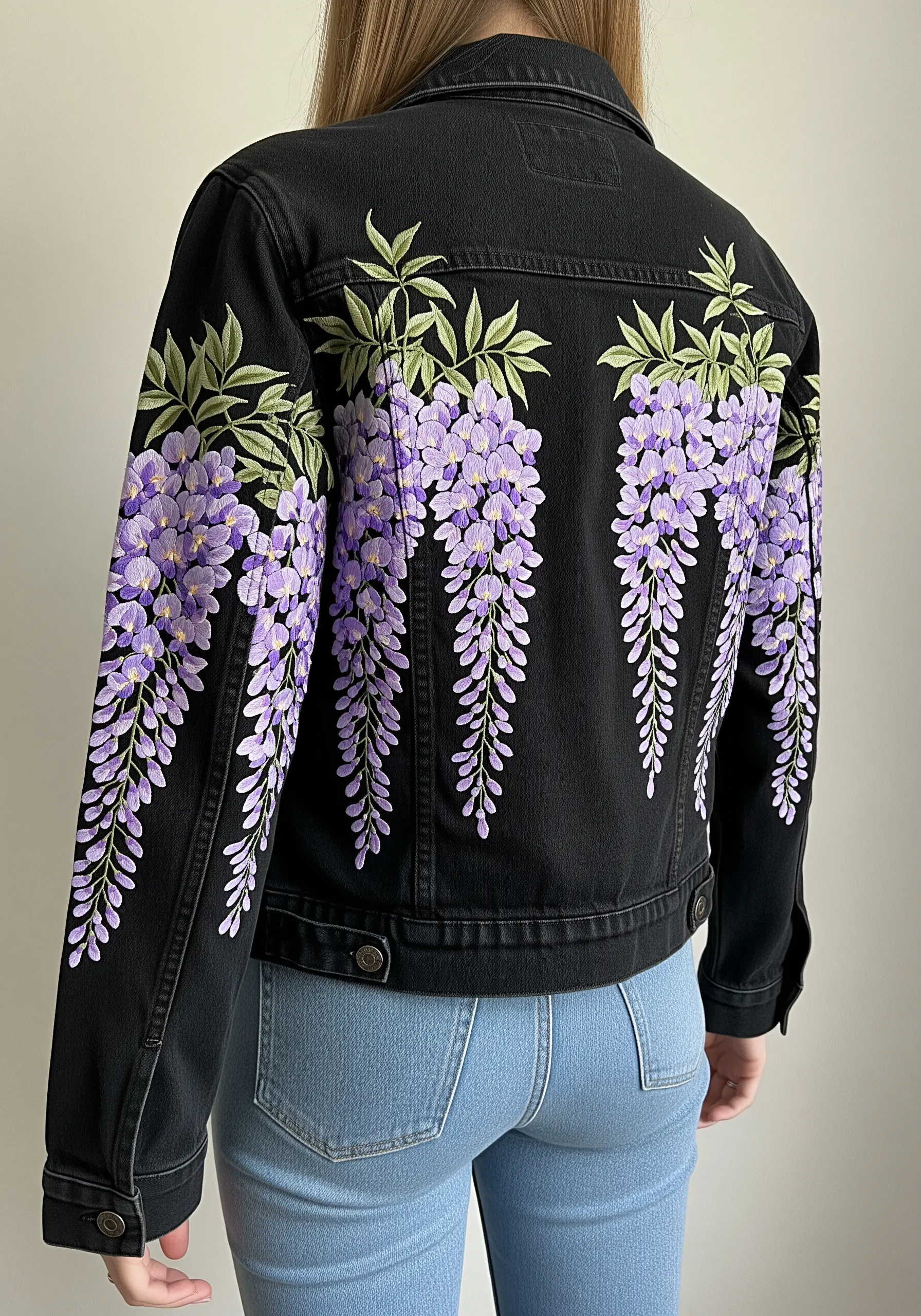 Purple wisteria embroidery cascading down the back and sleeves of a black denim jacket.