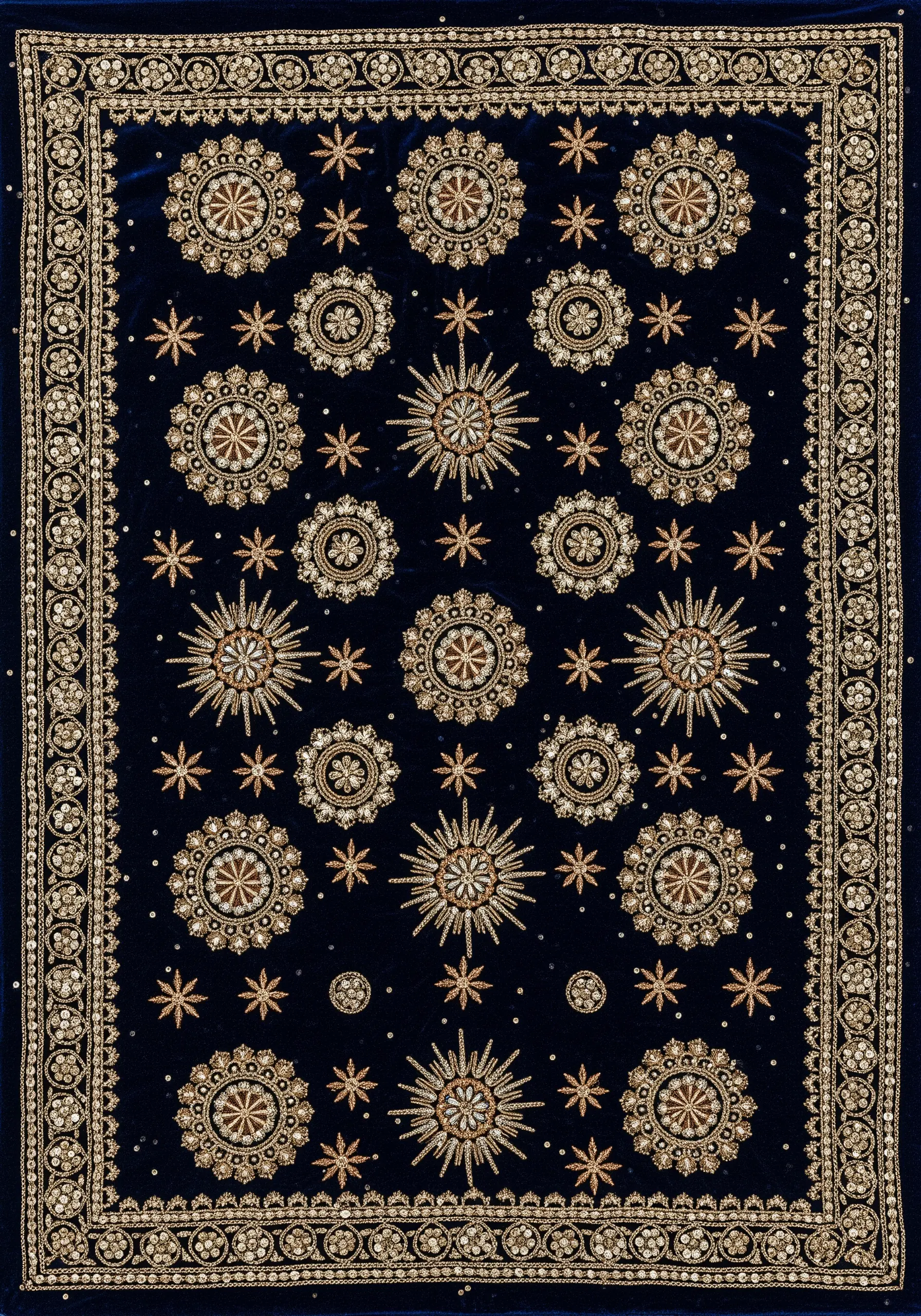 Intricate gold and silver beadwork and sequins in celestial patterns on navy blue velvet.