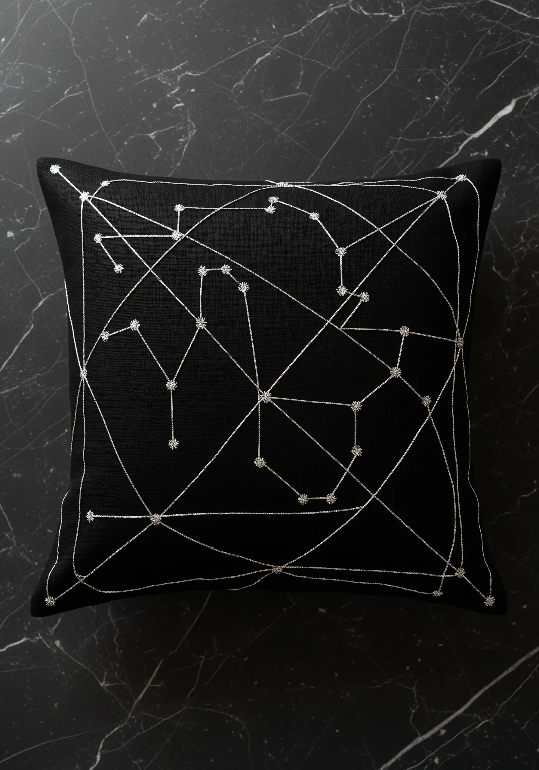 A geometric constellation stitched in silver thread with star stitch details on a black pillow.