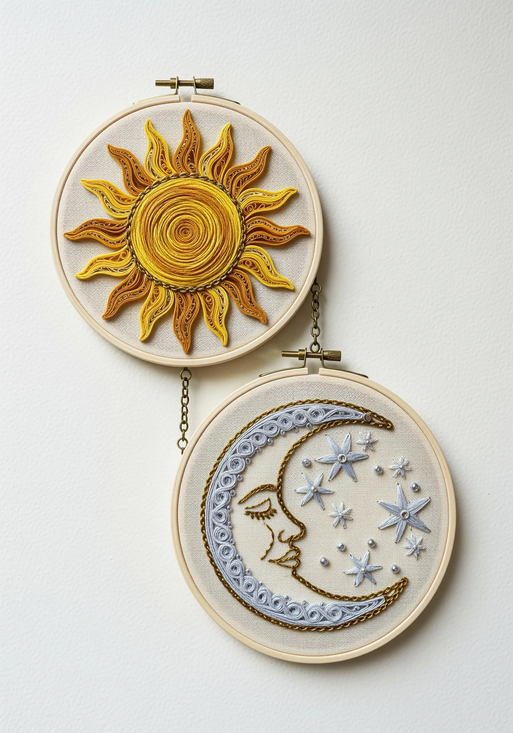 Two embroidery hoops showing a sun and moon created with a mix of paper quilling and embroidery.
