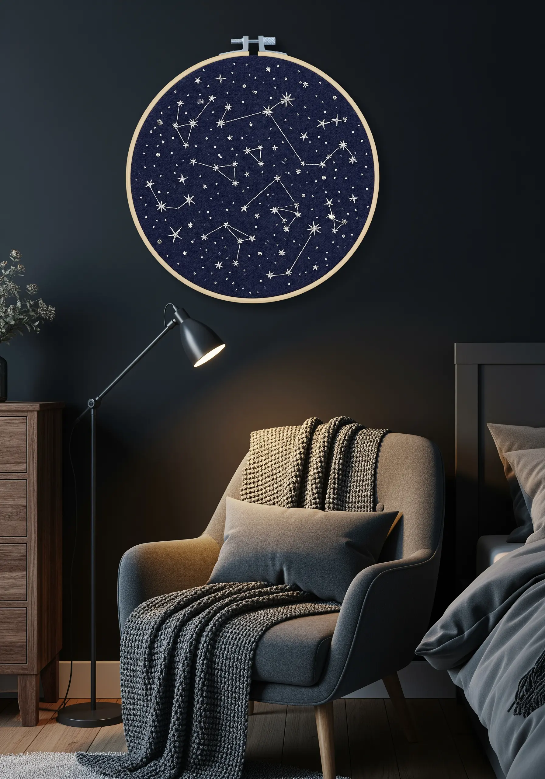 Embroidery hoop showing constellations stitched in white thread on a dark navy fabric.