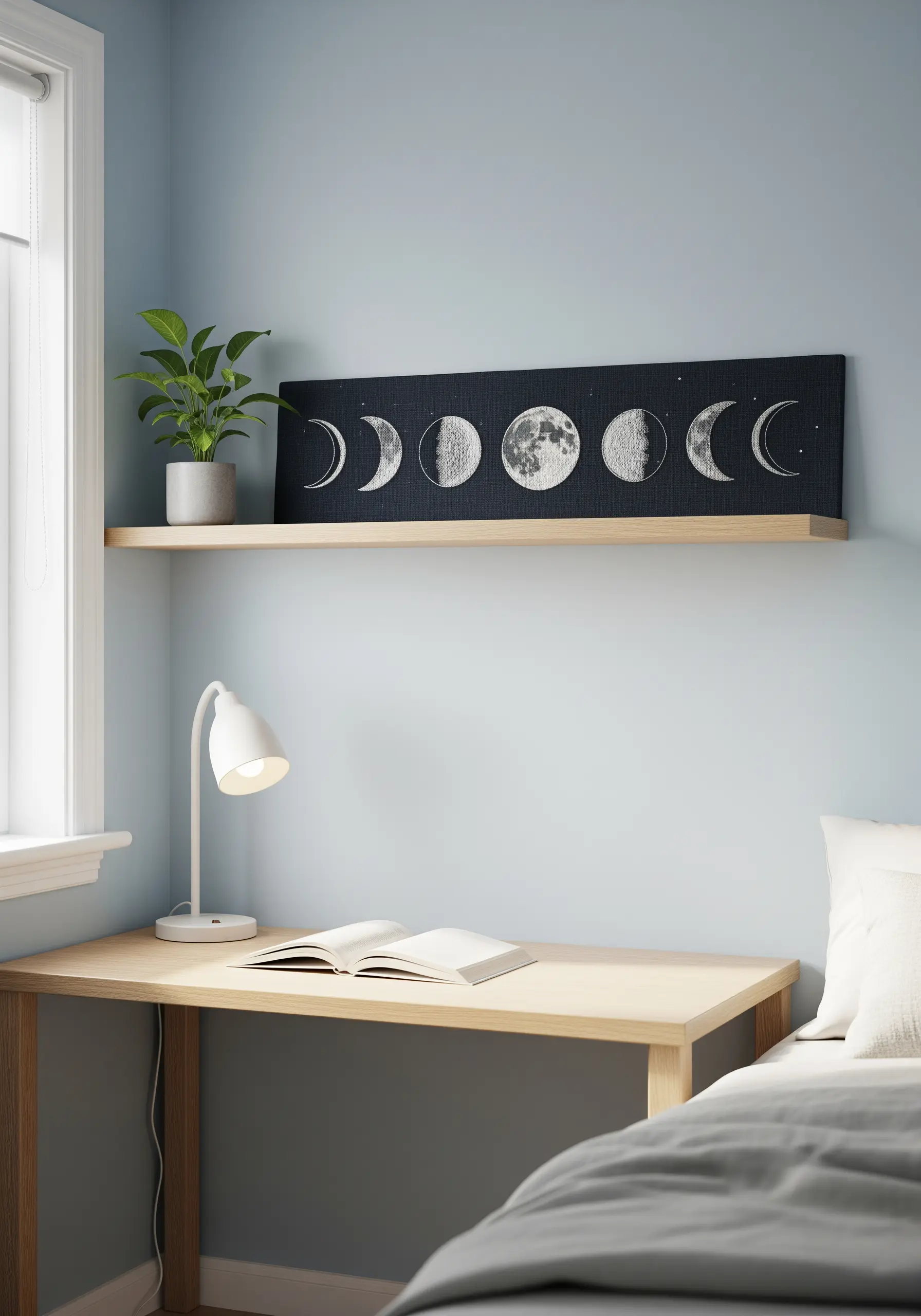 A long, horizontal embroidered panel showing the phases of the moon in white on black fabric.