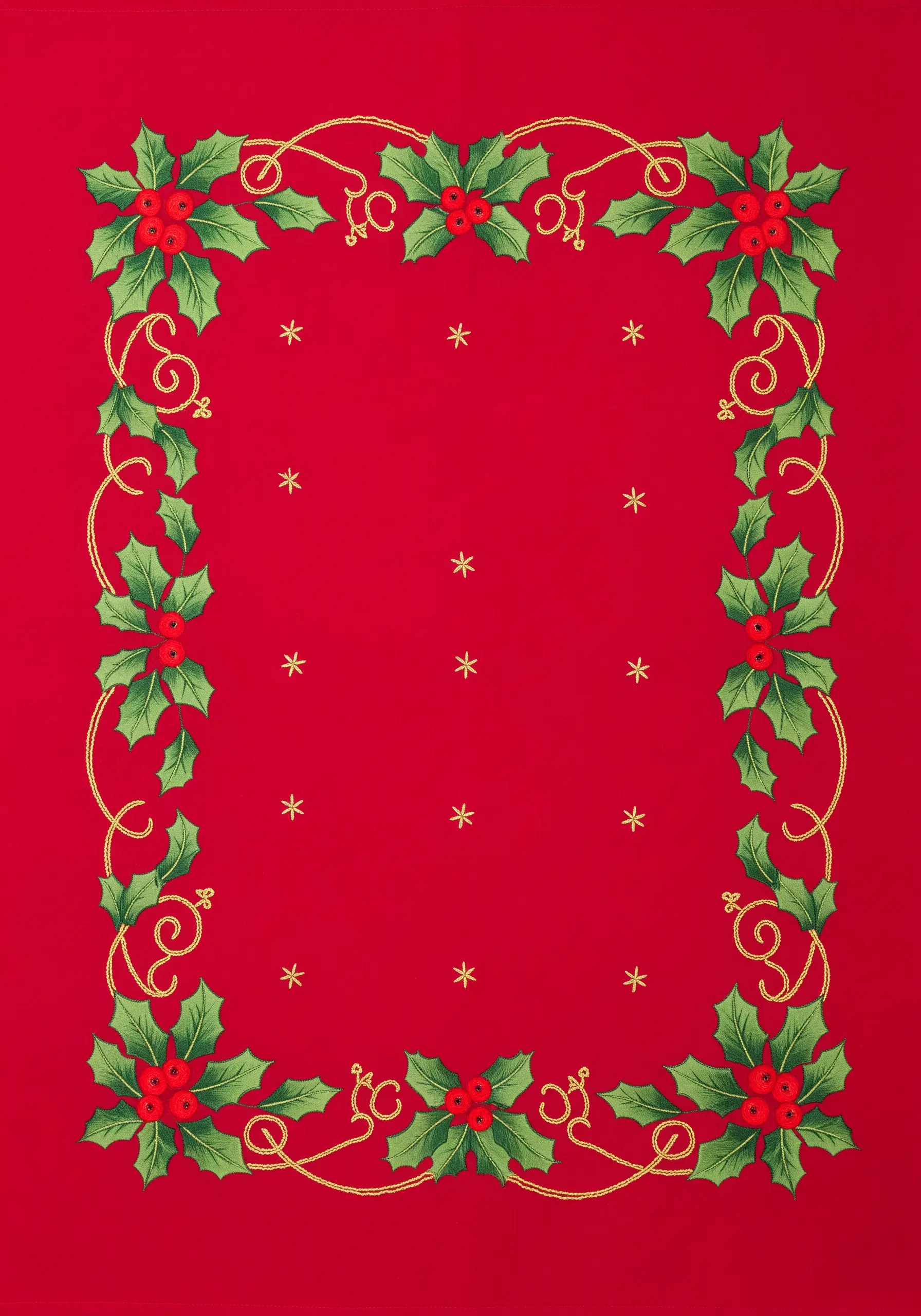 Embroidered holly and berry border with gold metallic thread on a red tablecloth.