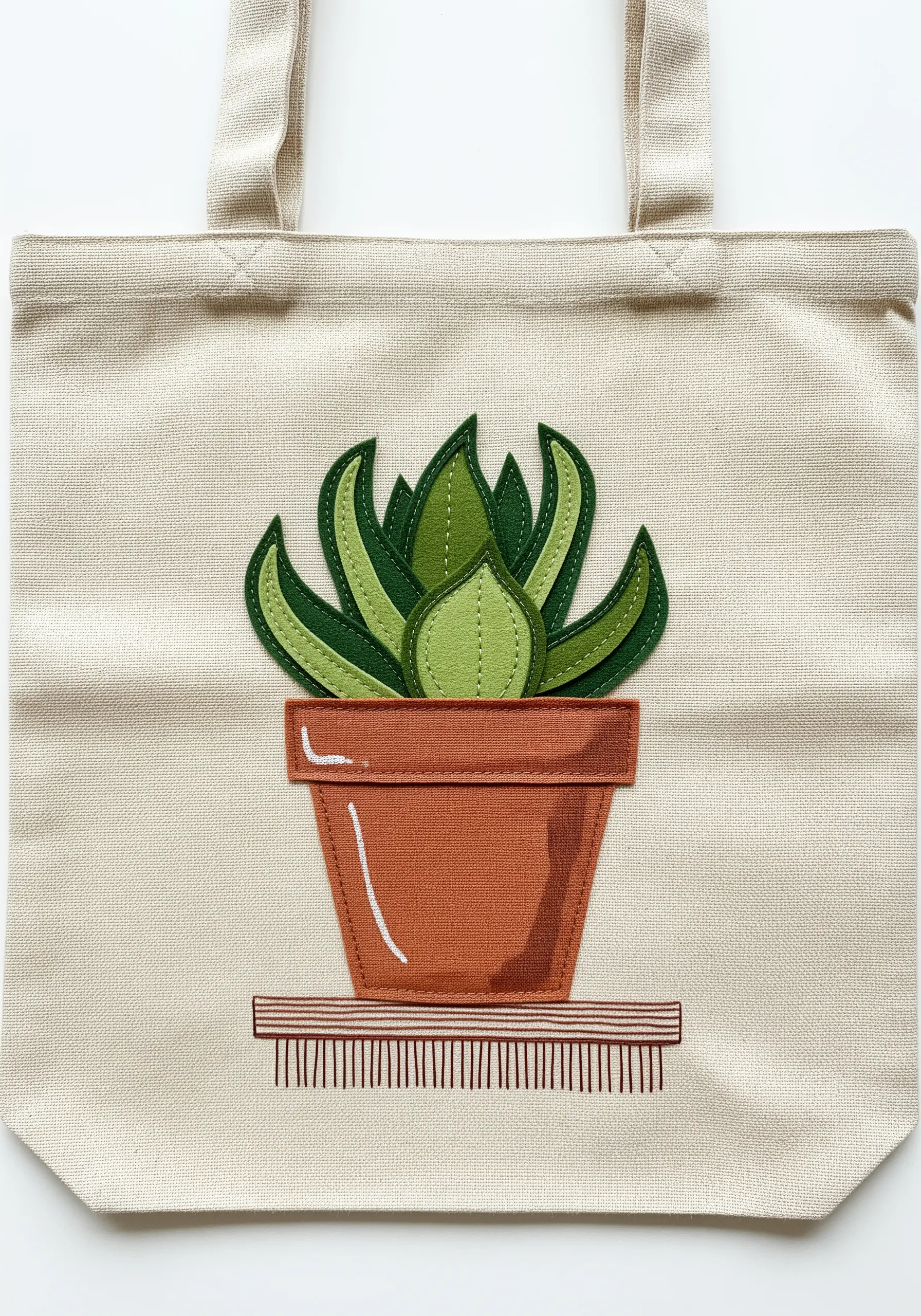 Minimalist green succulent in a terracotta pot, created with layered felt appliqué on a tote.