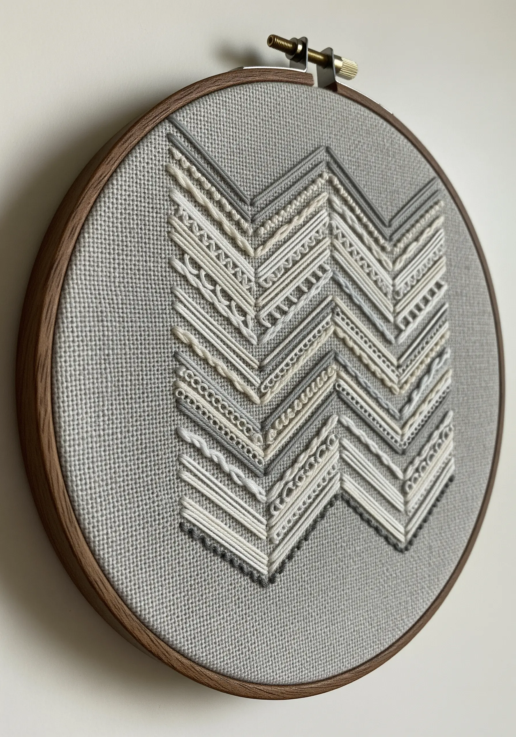 A chevron pattern filled with a sampler of different stitches in neutral tones.