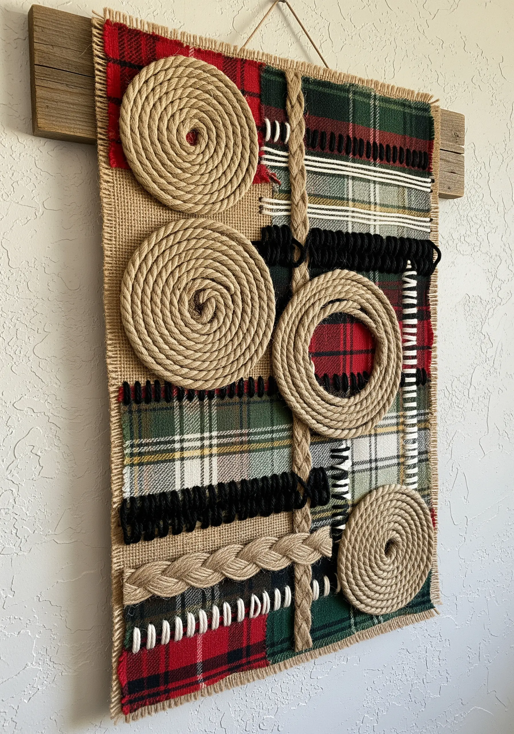 Rustic wall hanging collage with coiled jute rope on a background of plaid and burlap.