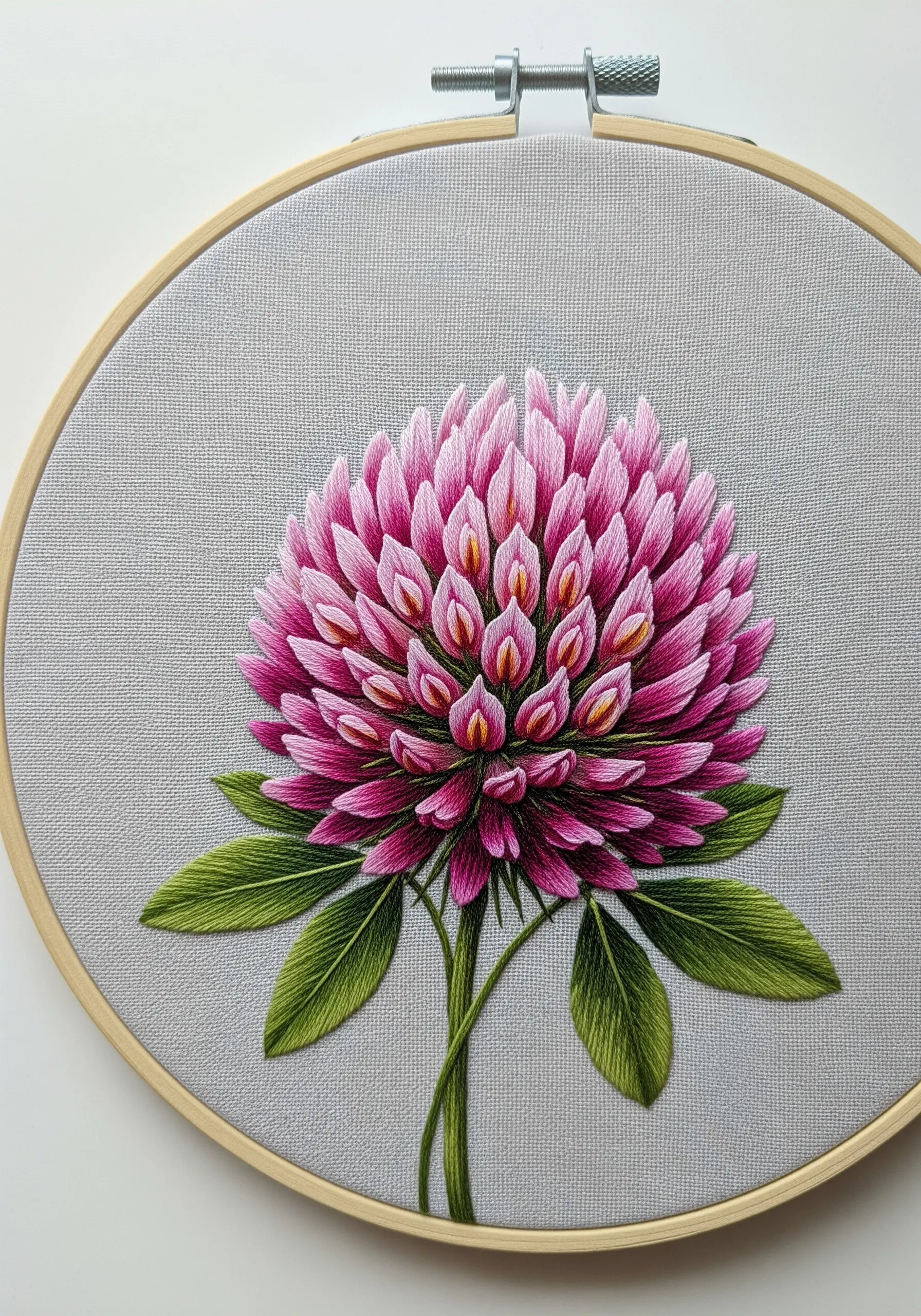 Detailed red clover embroidery with individually layered satin-stitched florets in shades of pink.
