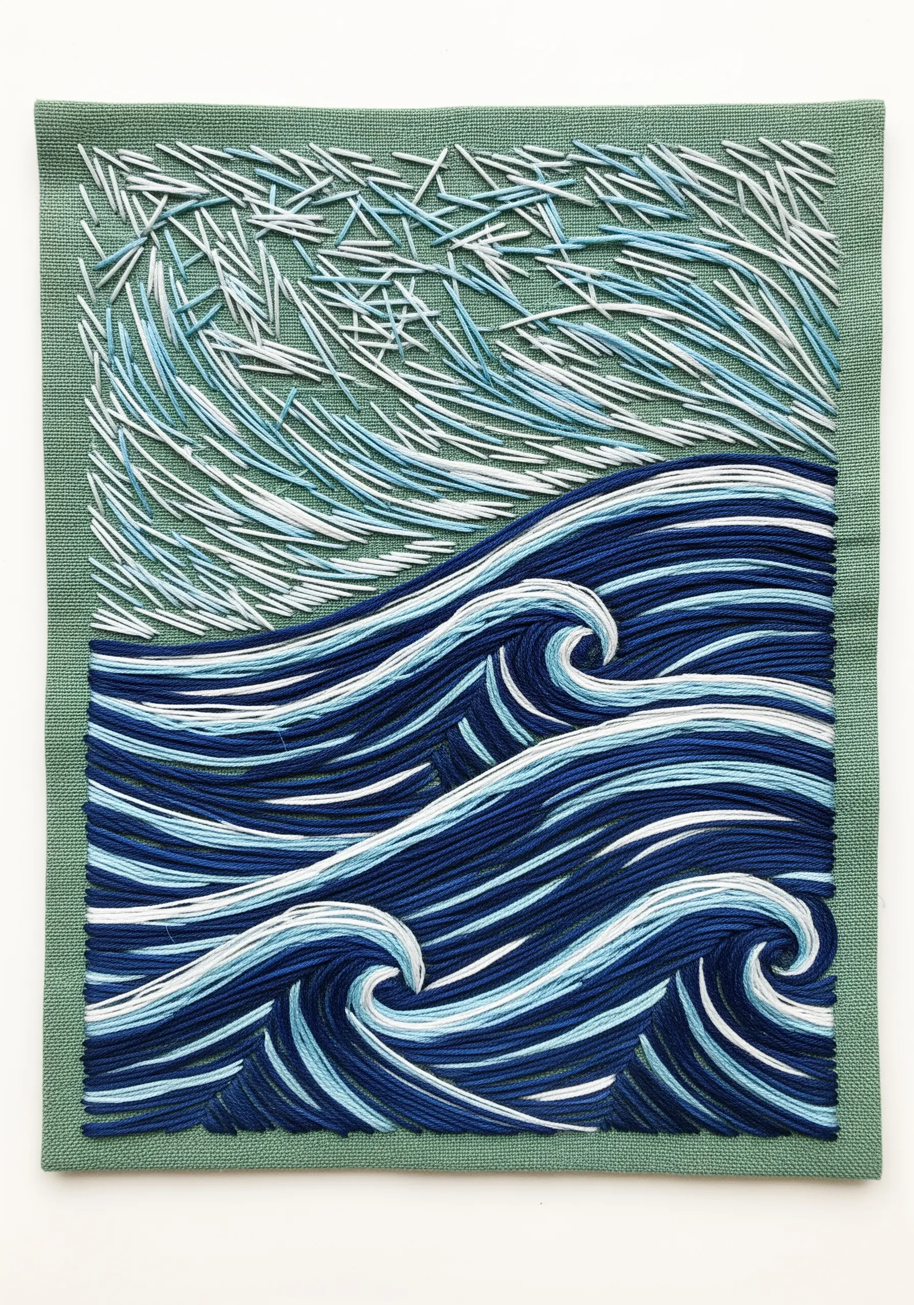 Abstract embroidery of stylized blue ocean waves below a sky of chaotic white and blue stitches.