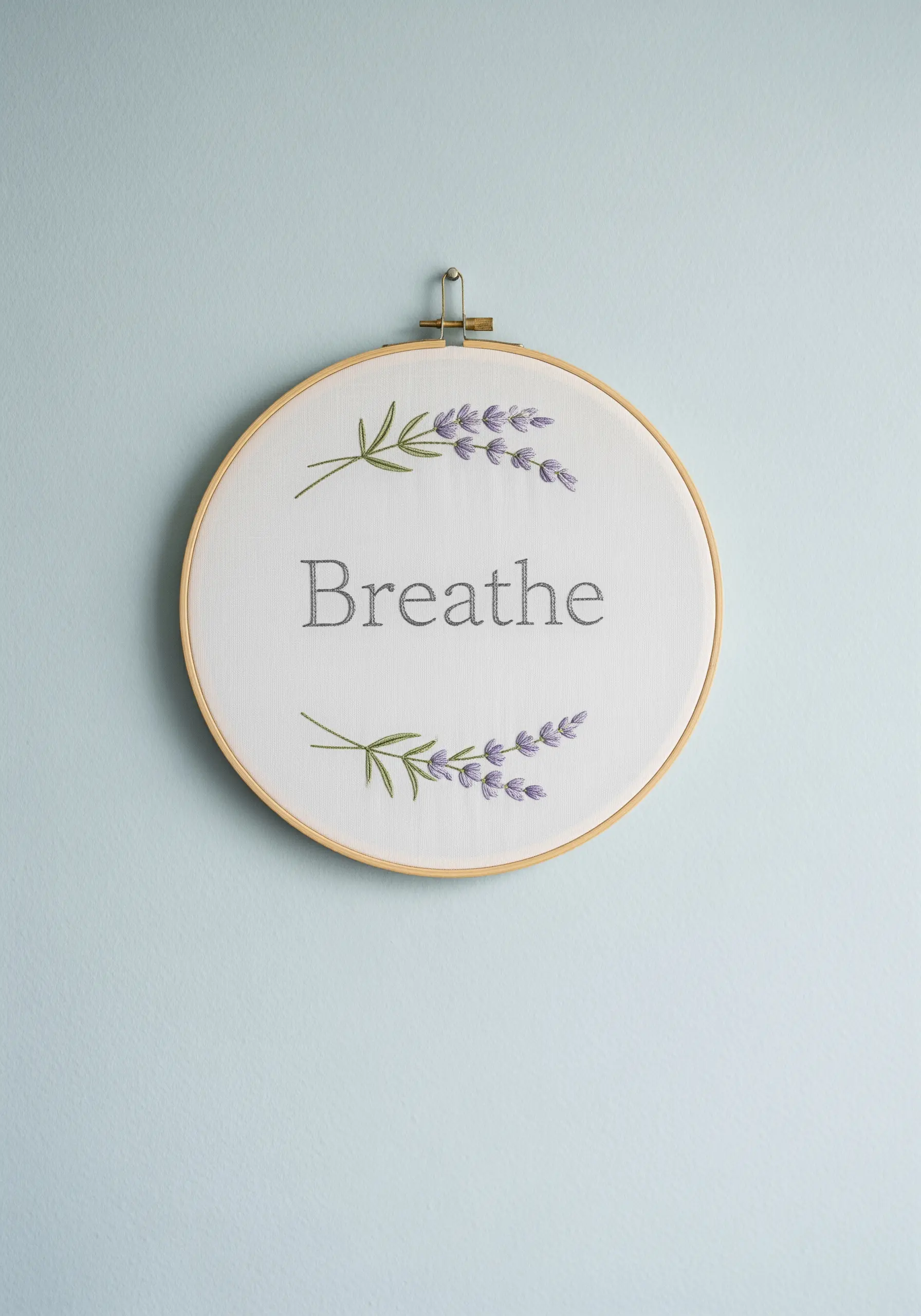 Minimalist embroidery of the word 'Breathe' flanked by two lavender sprigs.