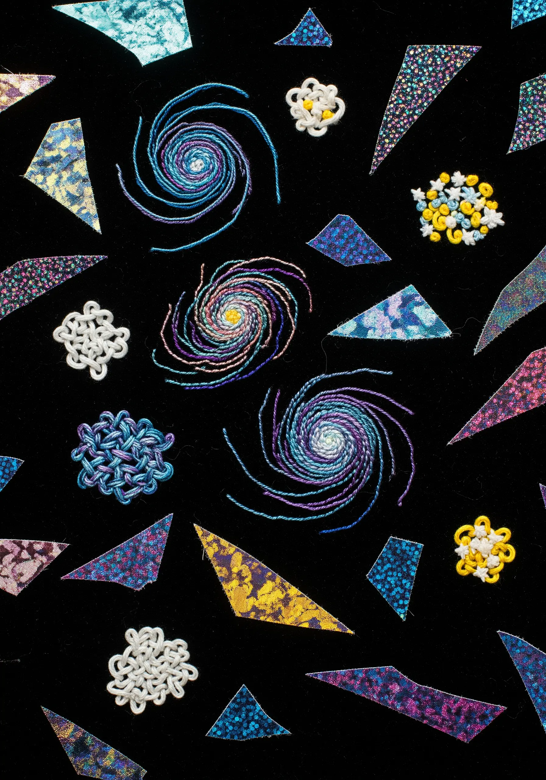 Abstract cosmic scene on black velvet with holographic fabric shapes and colorful thread spirals.