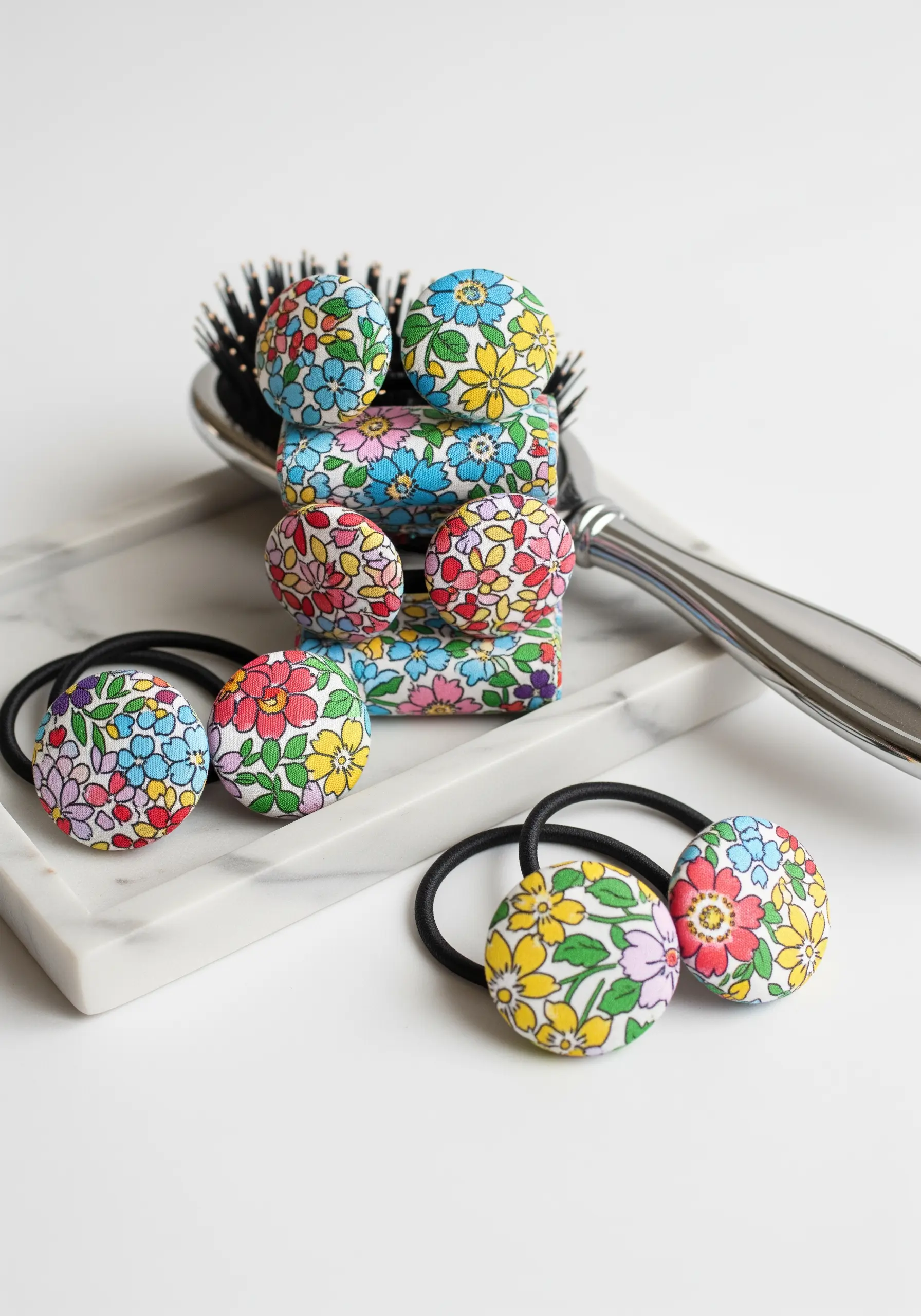 A collection of colorful fabric-covered buttons made into hair ties and barrettes.