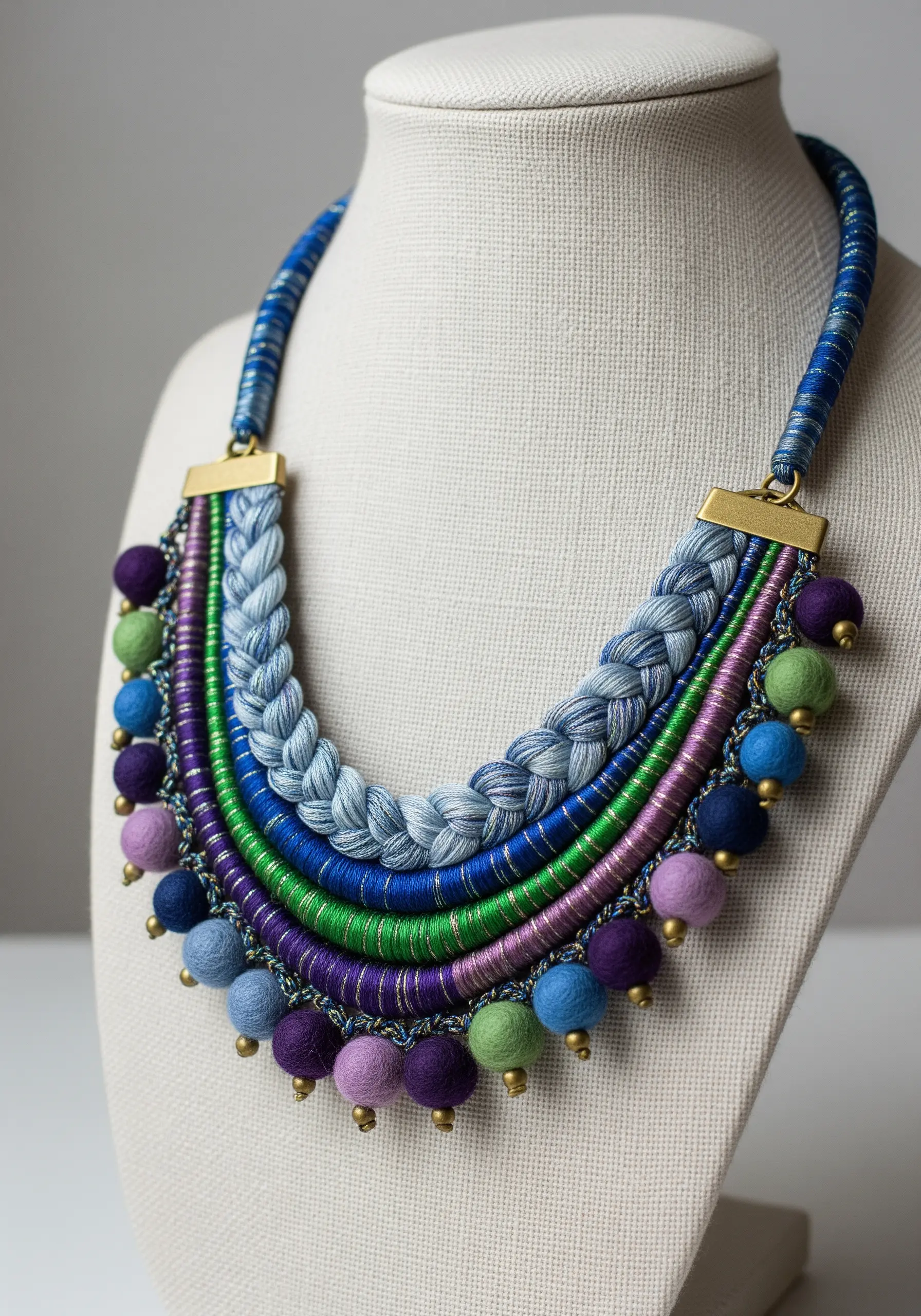 Statement bib necklace made from wrapped threads, braided cords, and felted beads.