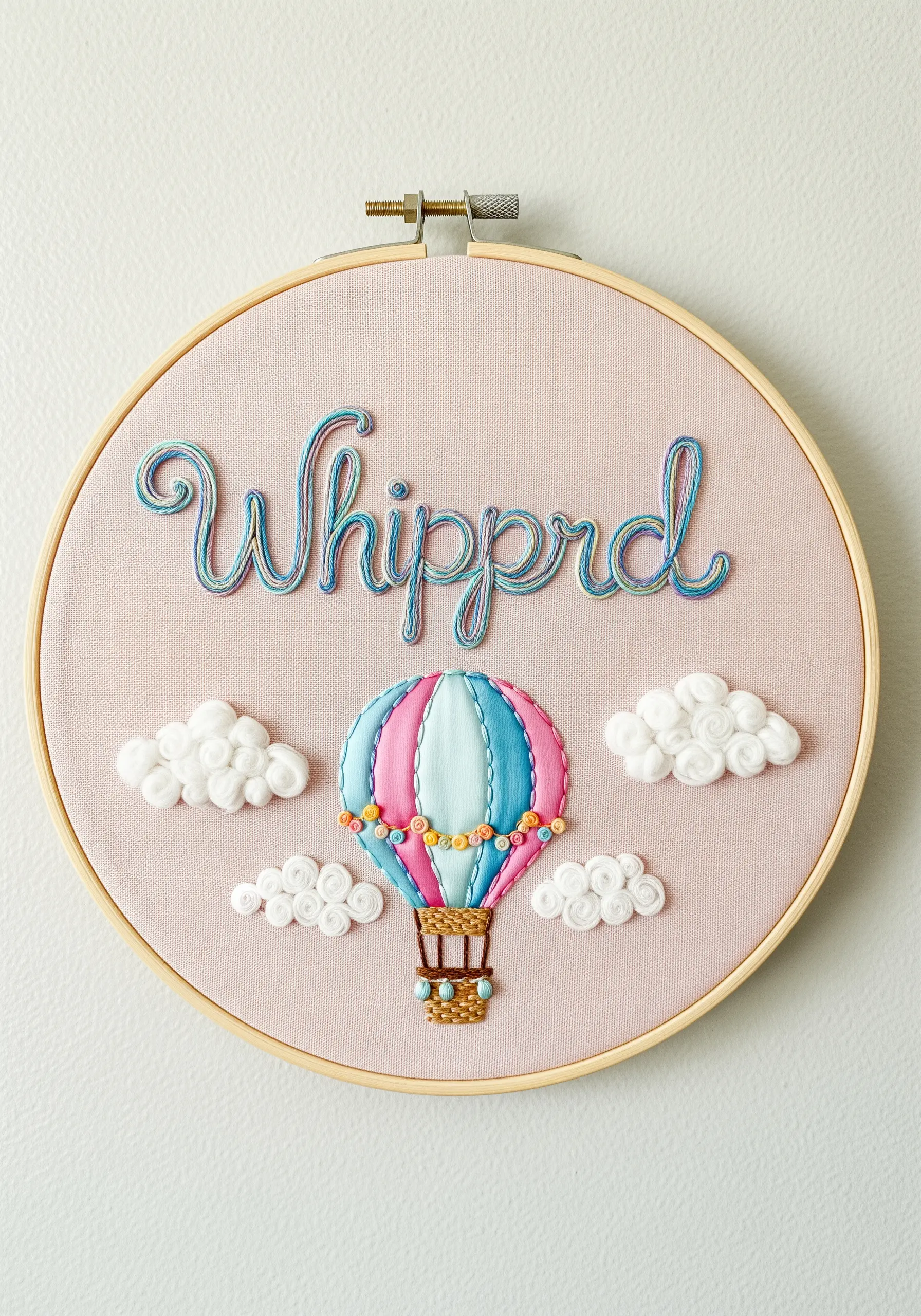 Nursery hoop art with a 3D hot air balloon, fluffy white clouds, and raised lettering.