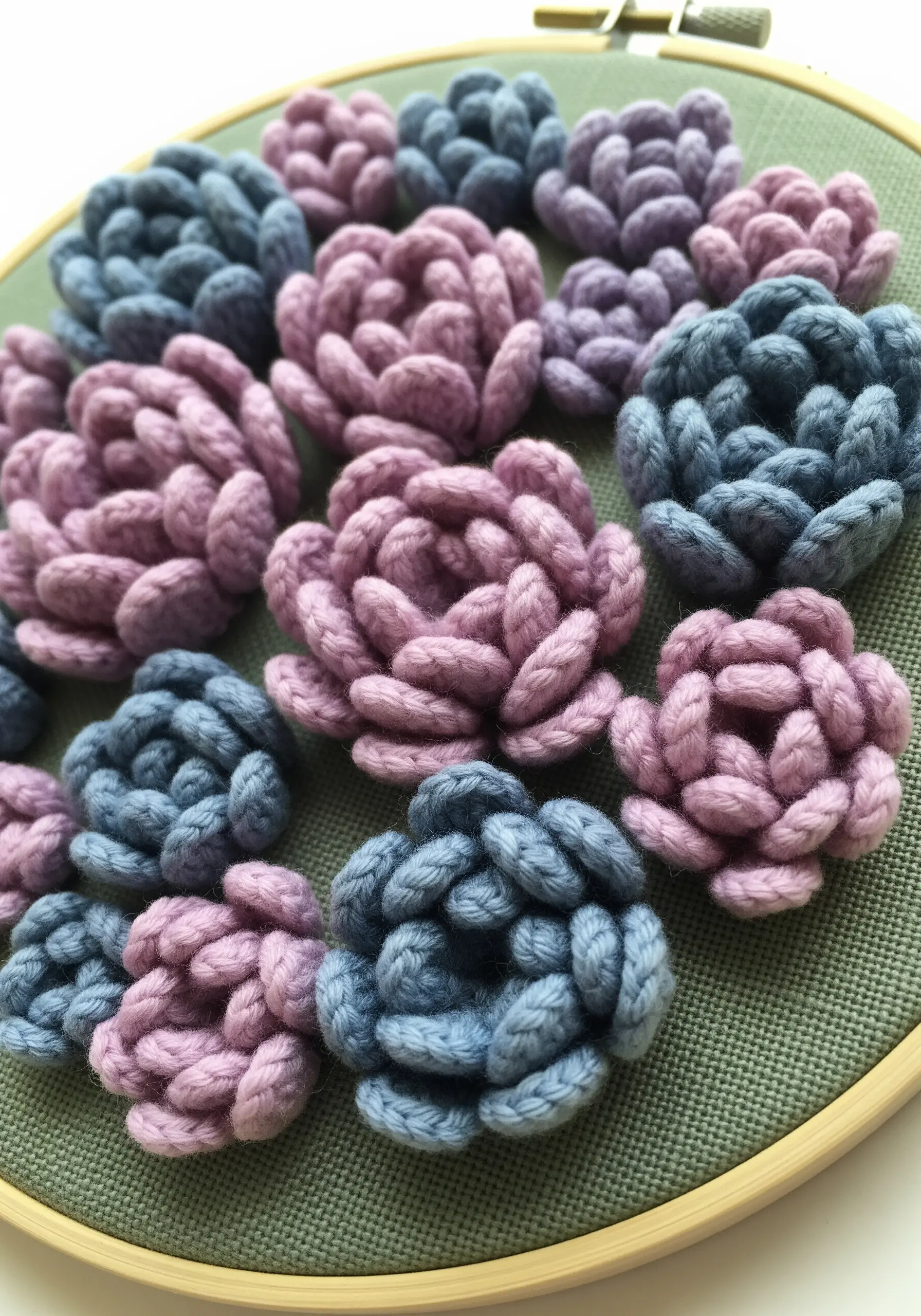 Raised, woven picot stitches in dusty blue and lavender creating 3D succulent shapes.