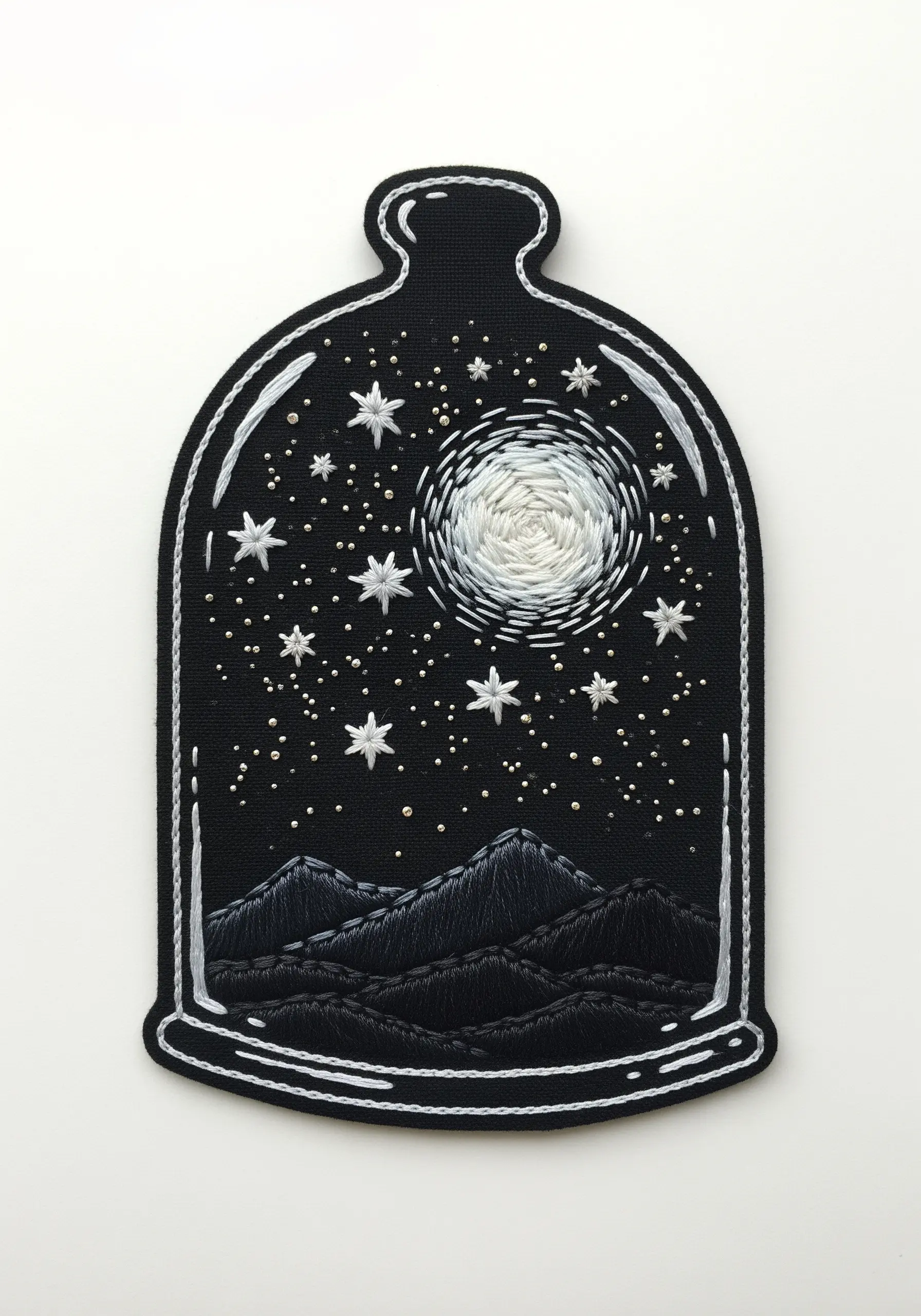 Embroidered patch of a night sky with a moon and mountains in a cloche