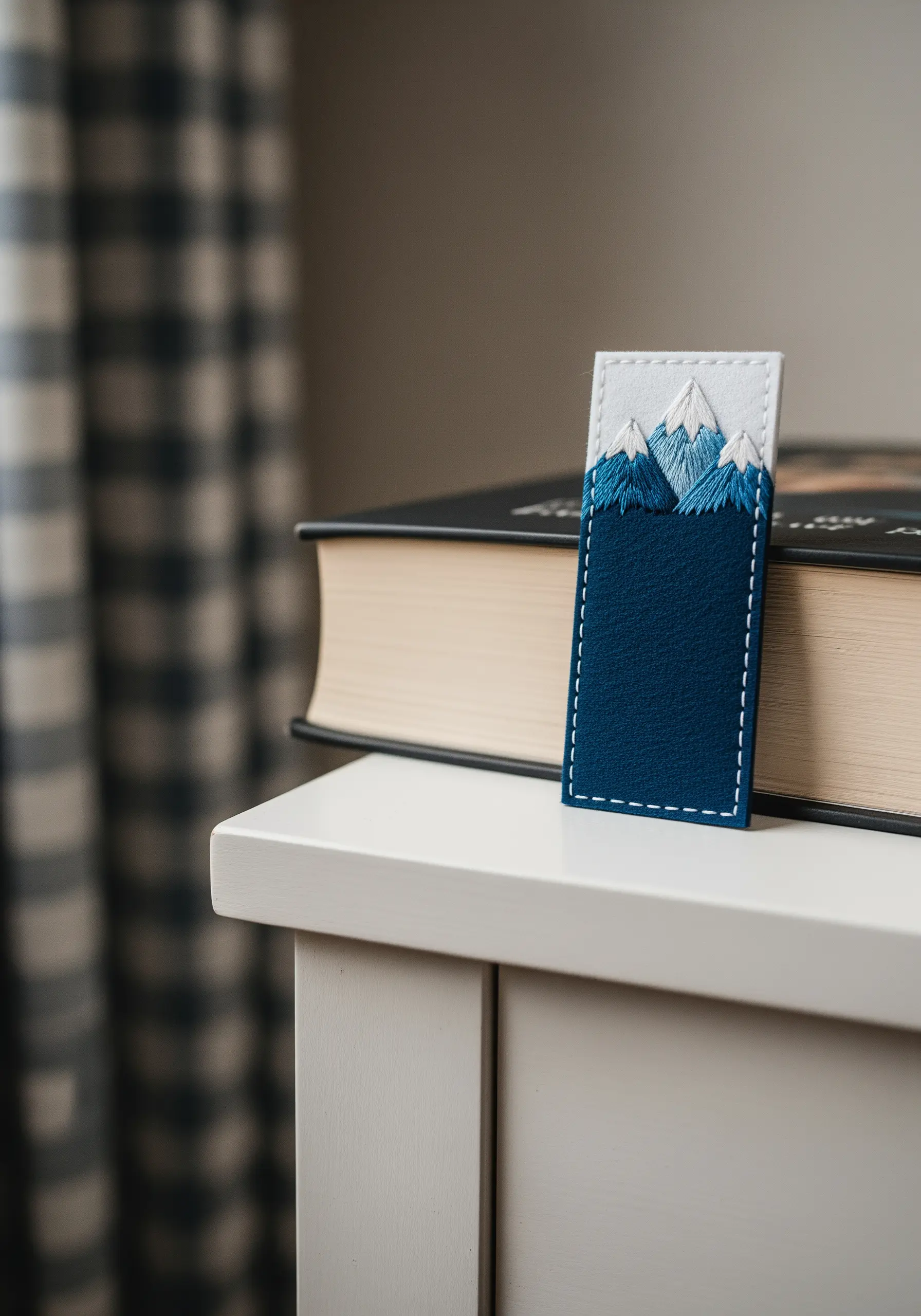 A bookmark made from layered blue and white felt, with embroidered snow-capped mountains.
