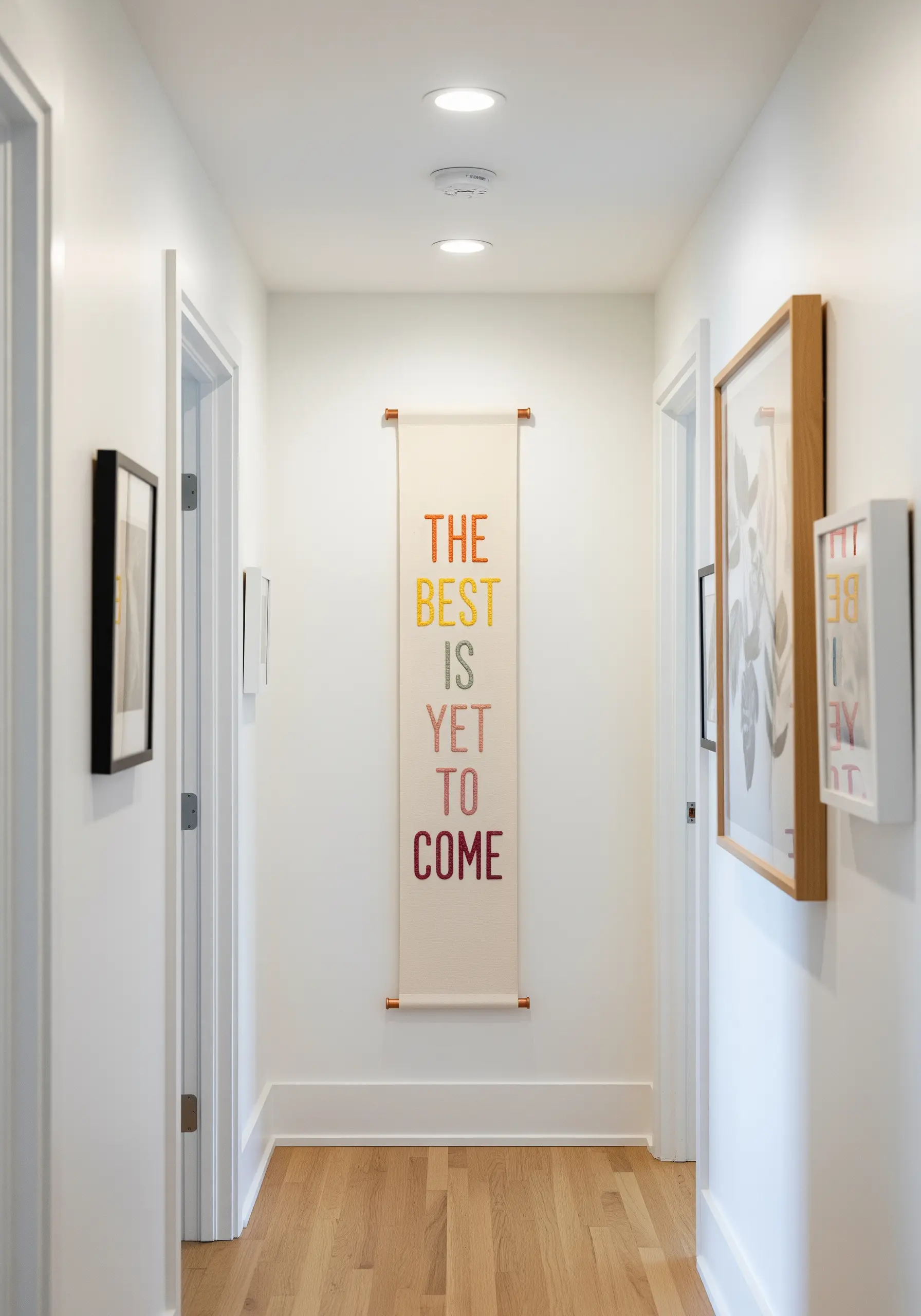A long, narrow wall banner with a quote stitched in a colorful gradient from orange to pink.
