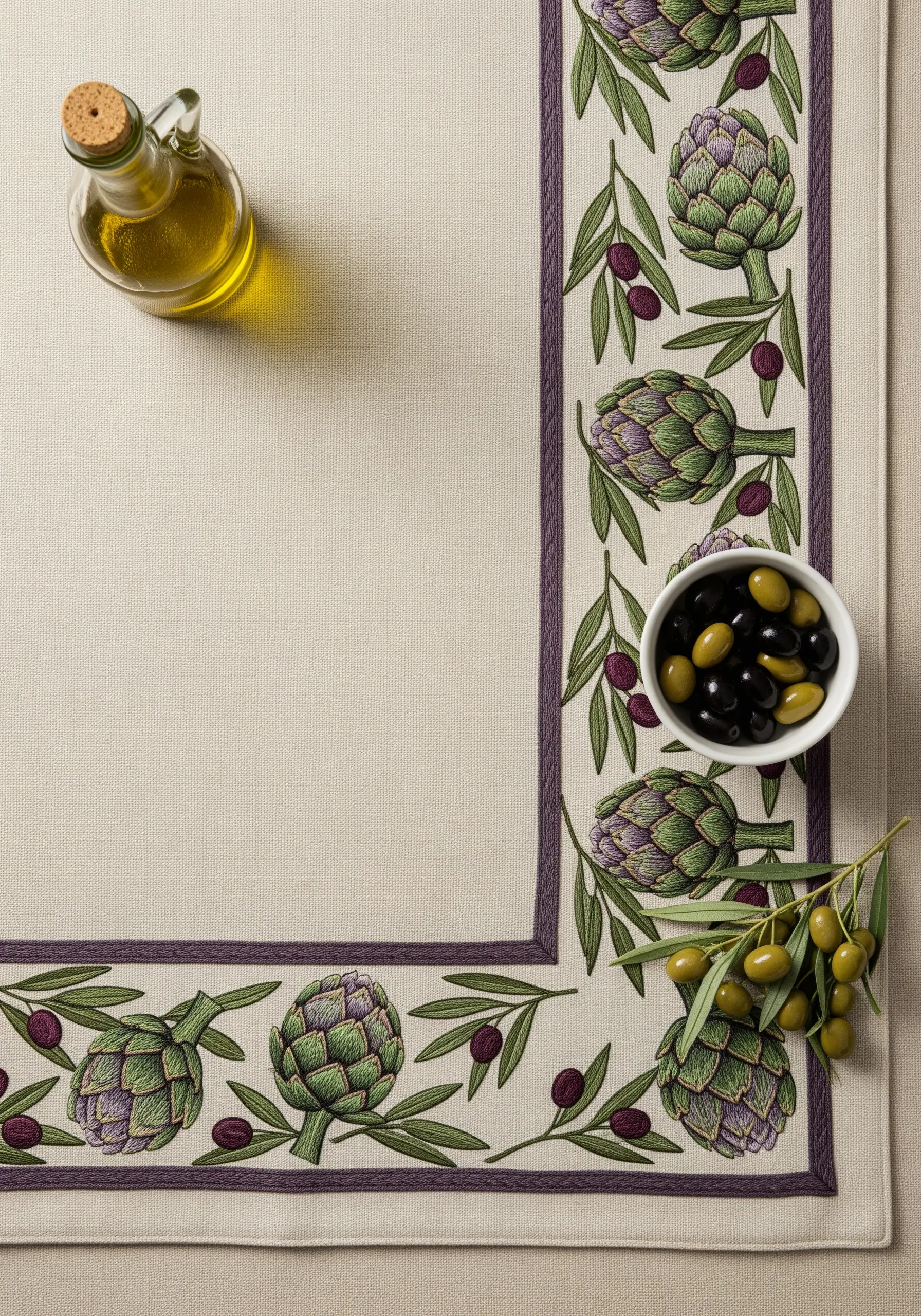 A placemat with an embroidered border of artichokes, olives, and leaves.