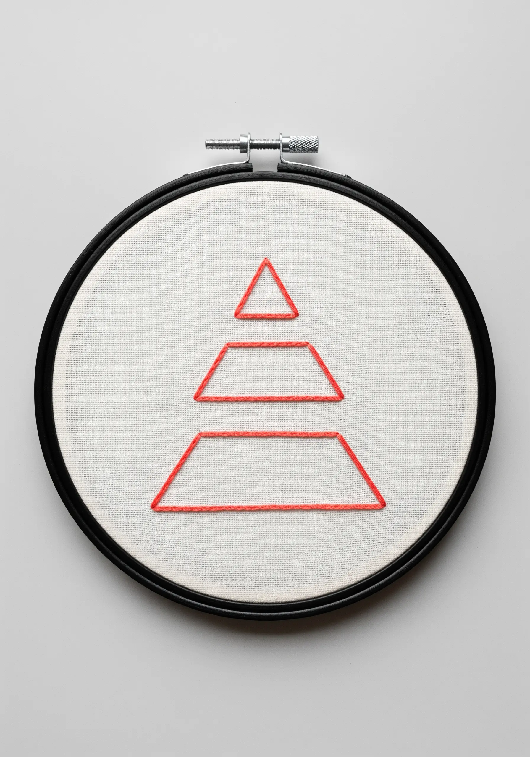 A geometric abstract shape made of stacked trapezoids outlined in red thread.