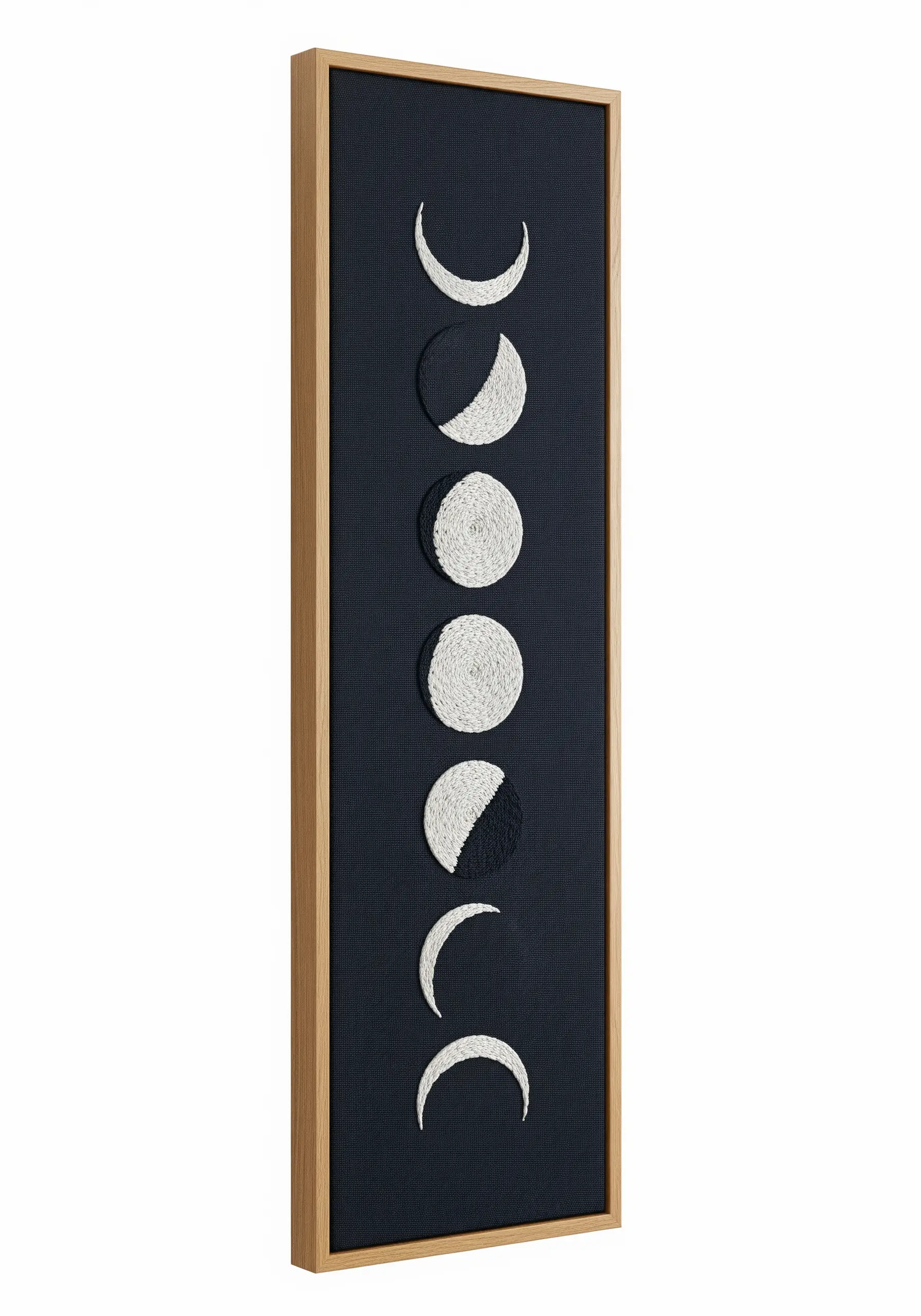 A tall, narrow framed embroidery piece showing the phases of the moon on a black background.