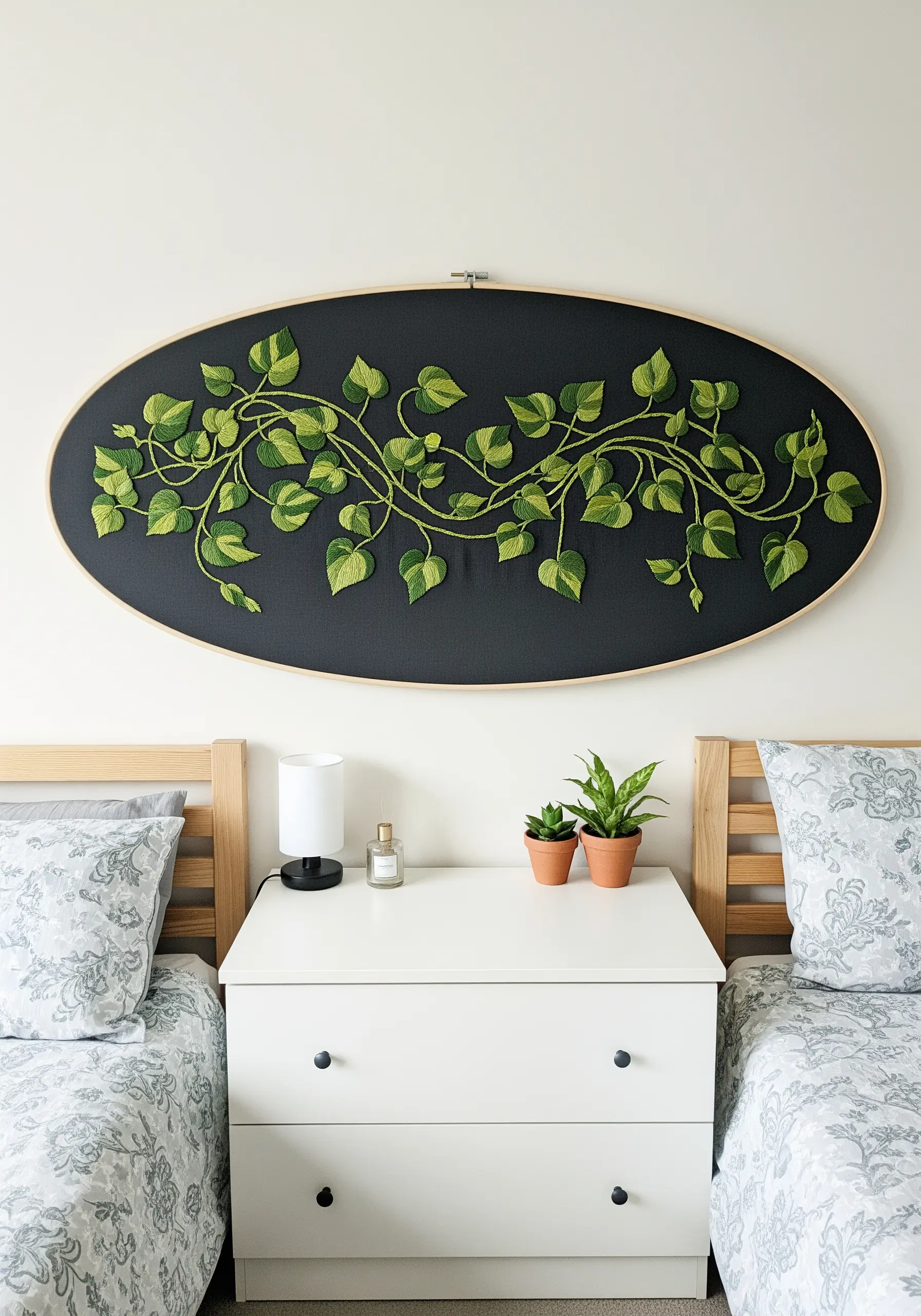Long, embroidered pothos vine with variegated leaves in an oval hoop.