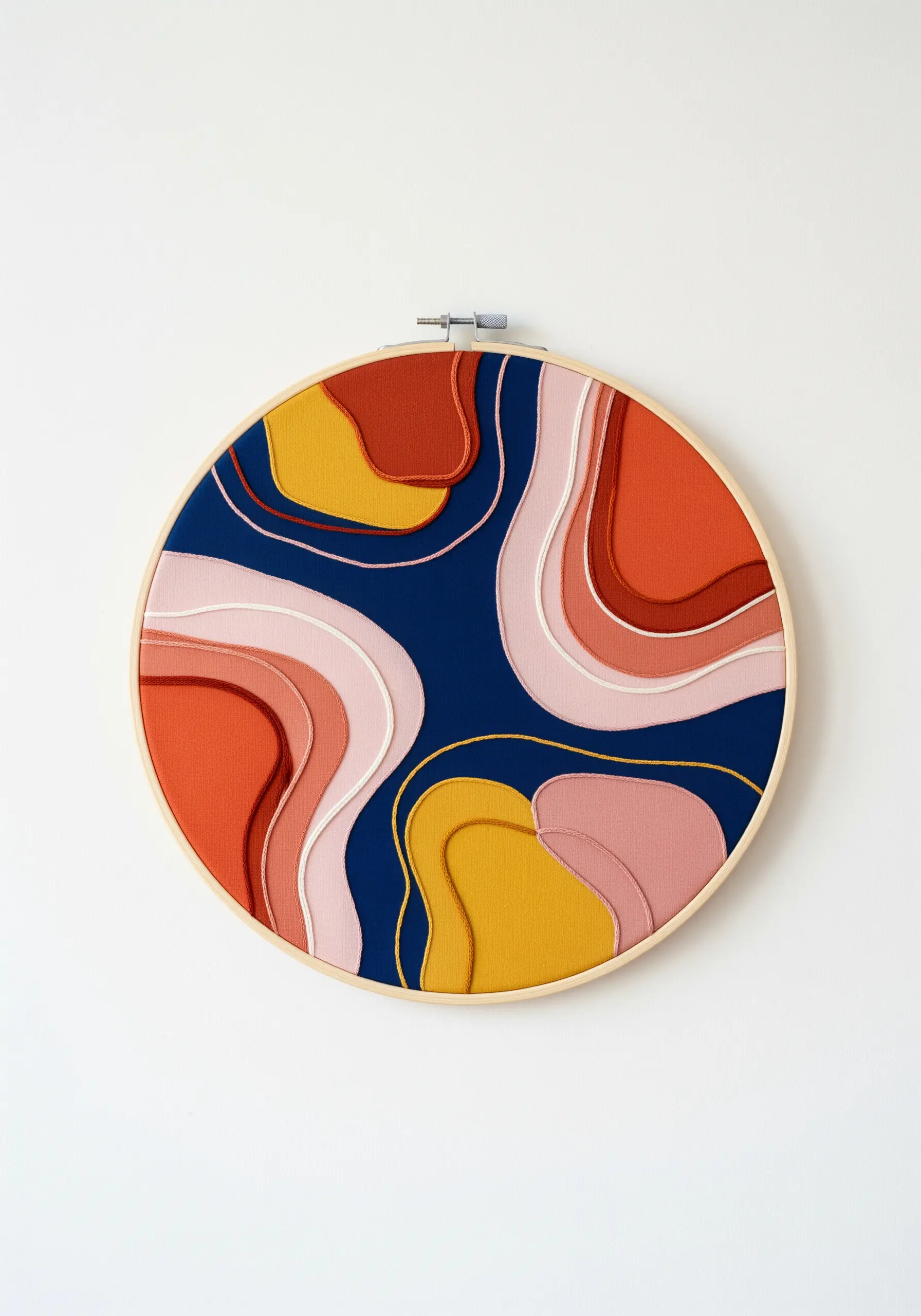 Abstract embroidery with layered satin stitch in warm tones on navy fabric.