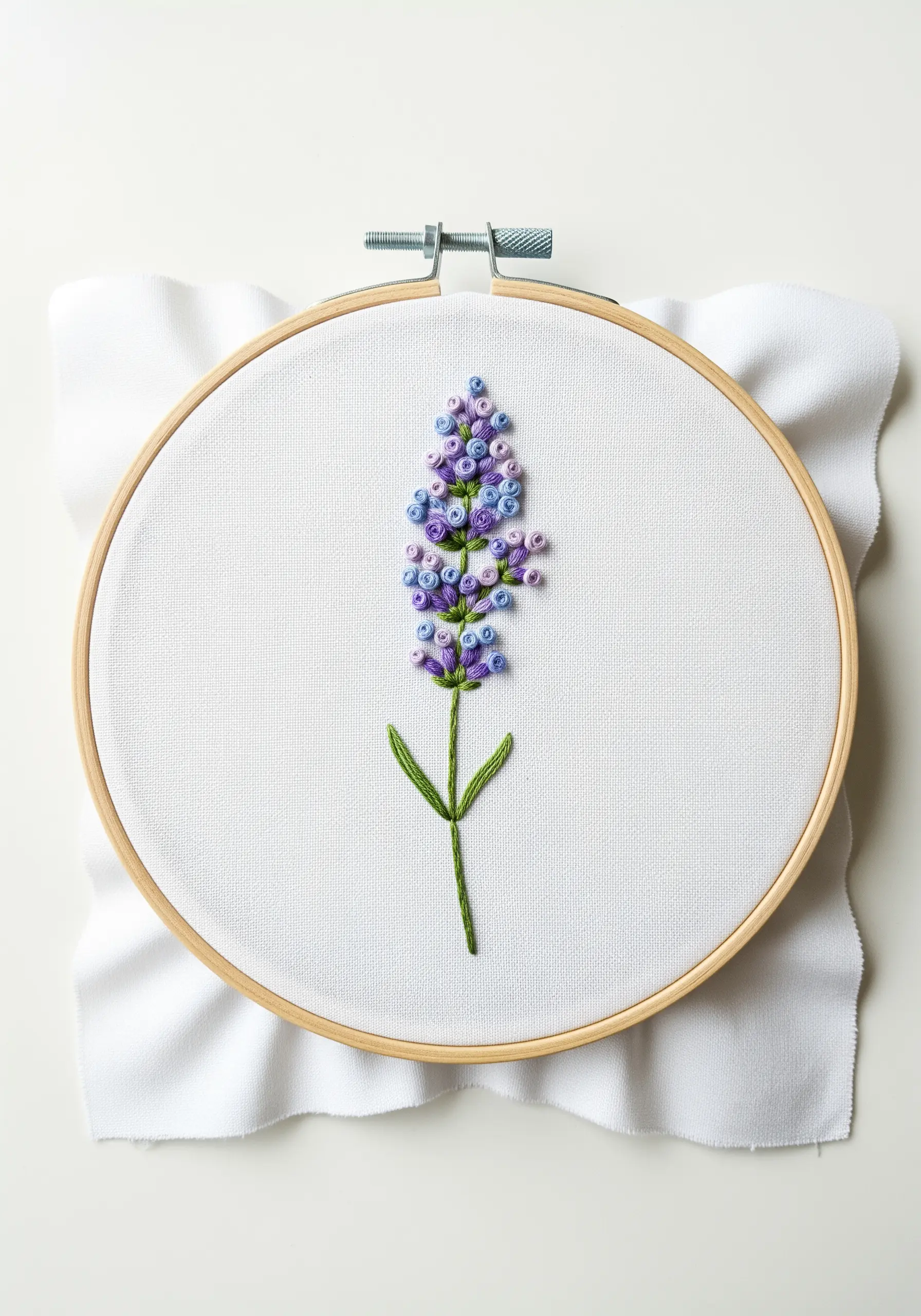 A lavender stalk embroidered with purple and blue French knots of varying sizes.
