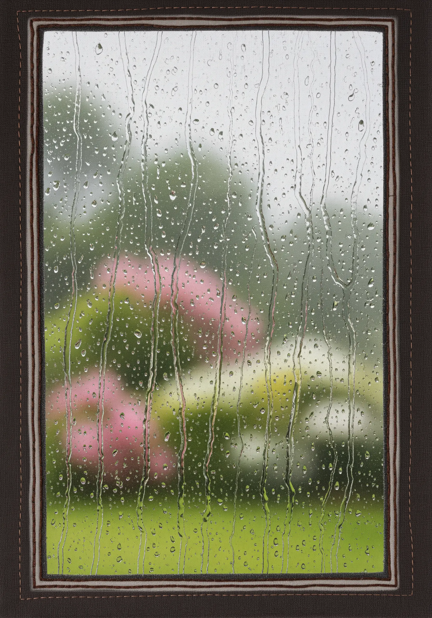 Photorealistic embroidery of a rainy window, with a garden scene blurred in the background.