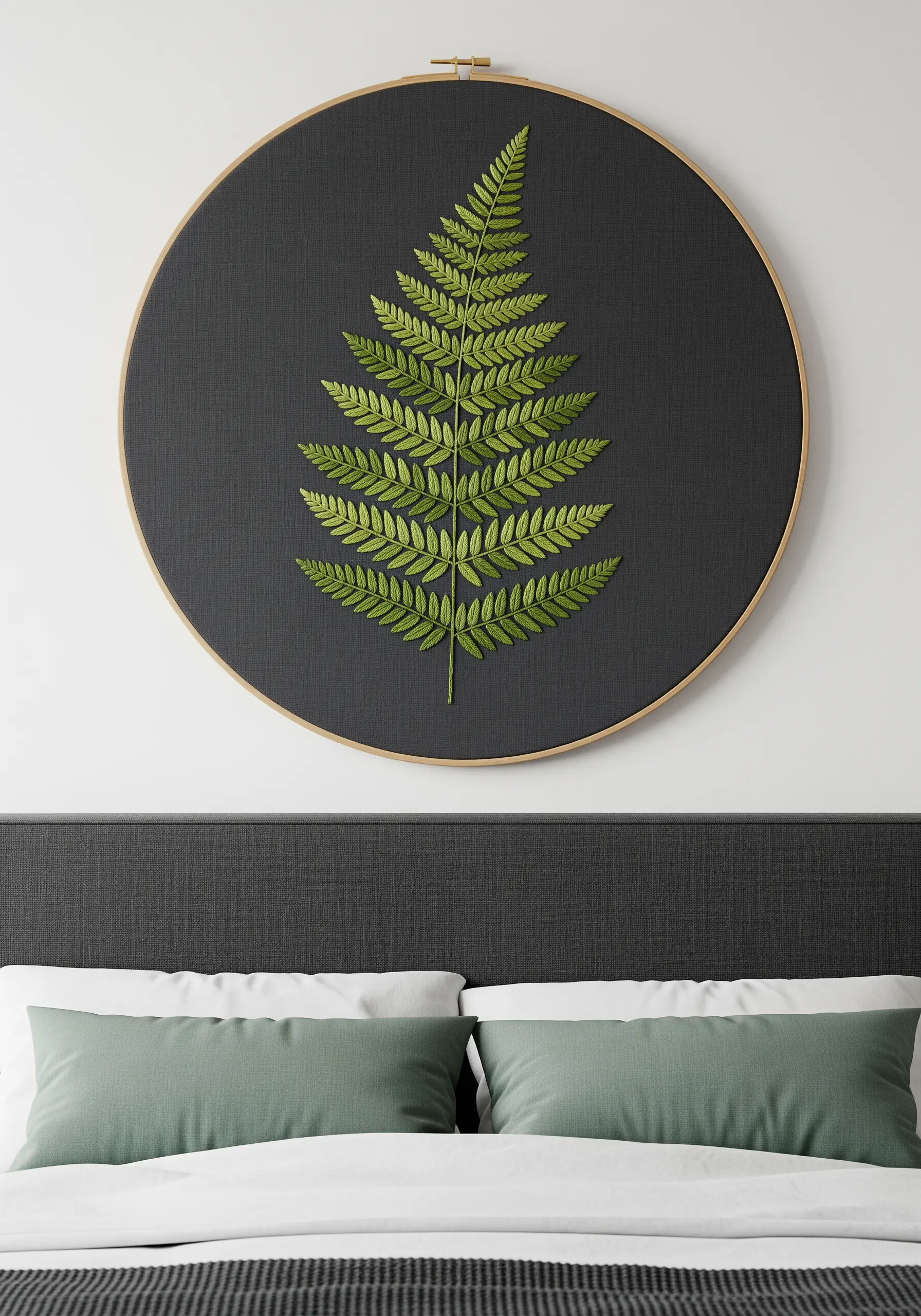 Large, realistic fern leaf embroidered with satin stitch on dark fabric above a bed.