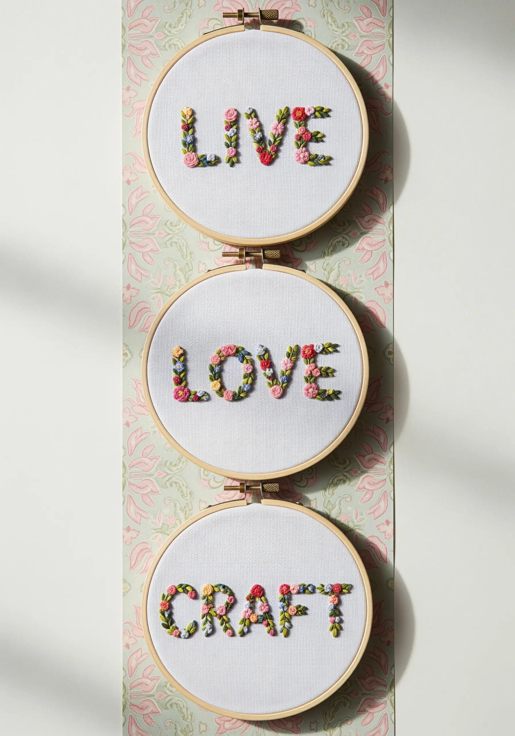 Three vertical hoops with letters formed entirely from tiny flowers