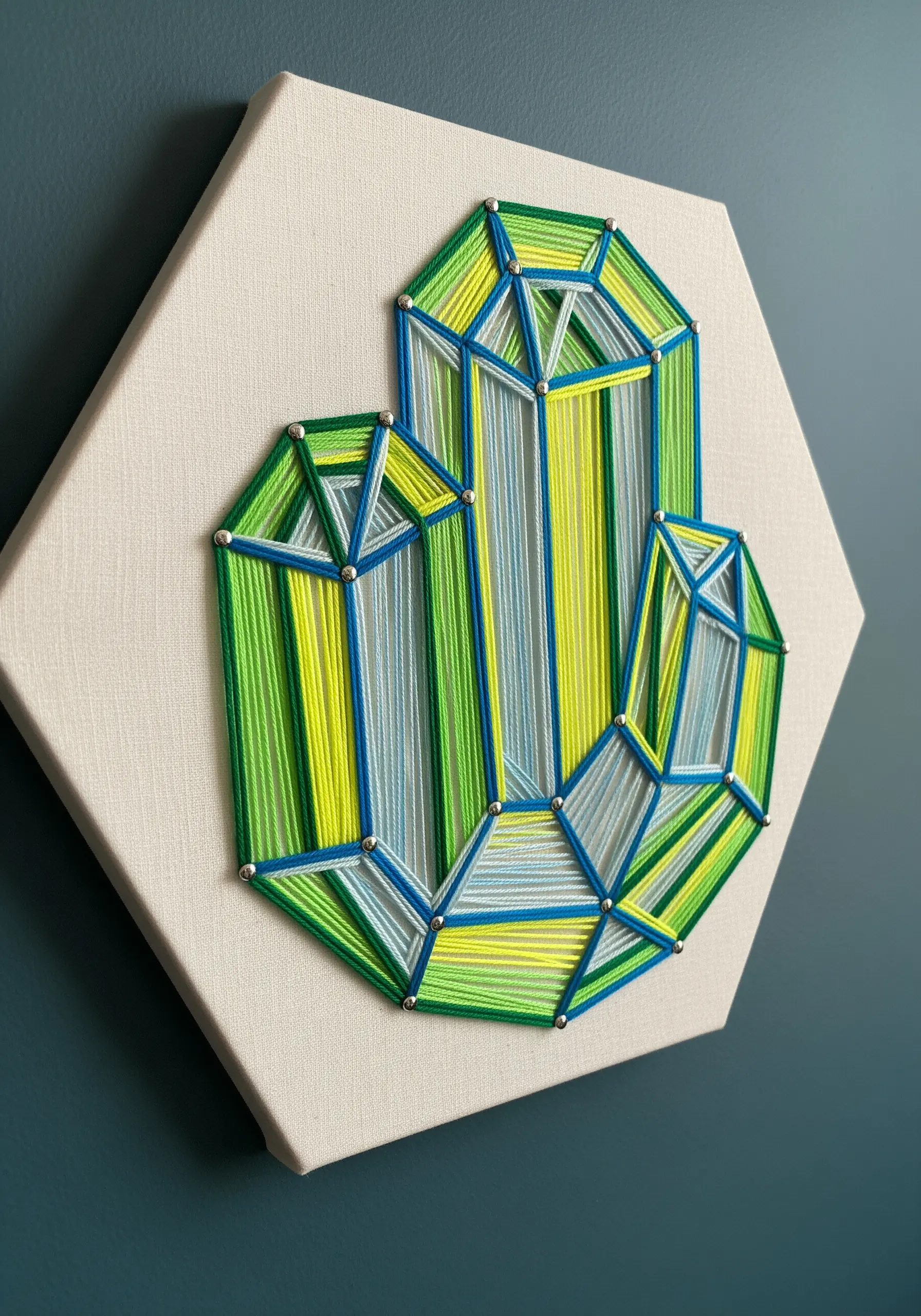 Geometric crystal cluster string art embroidery with green, yellow, and blue sections.