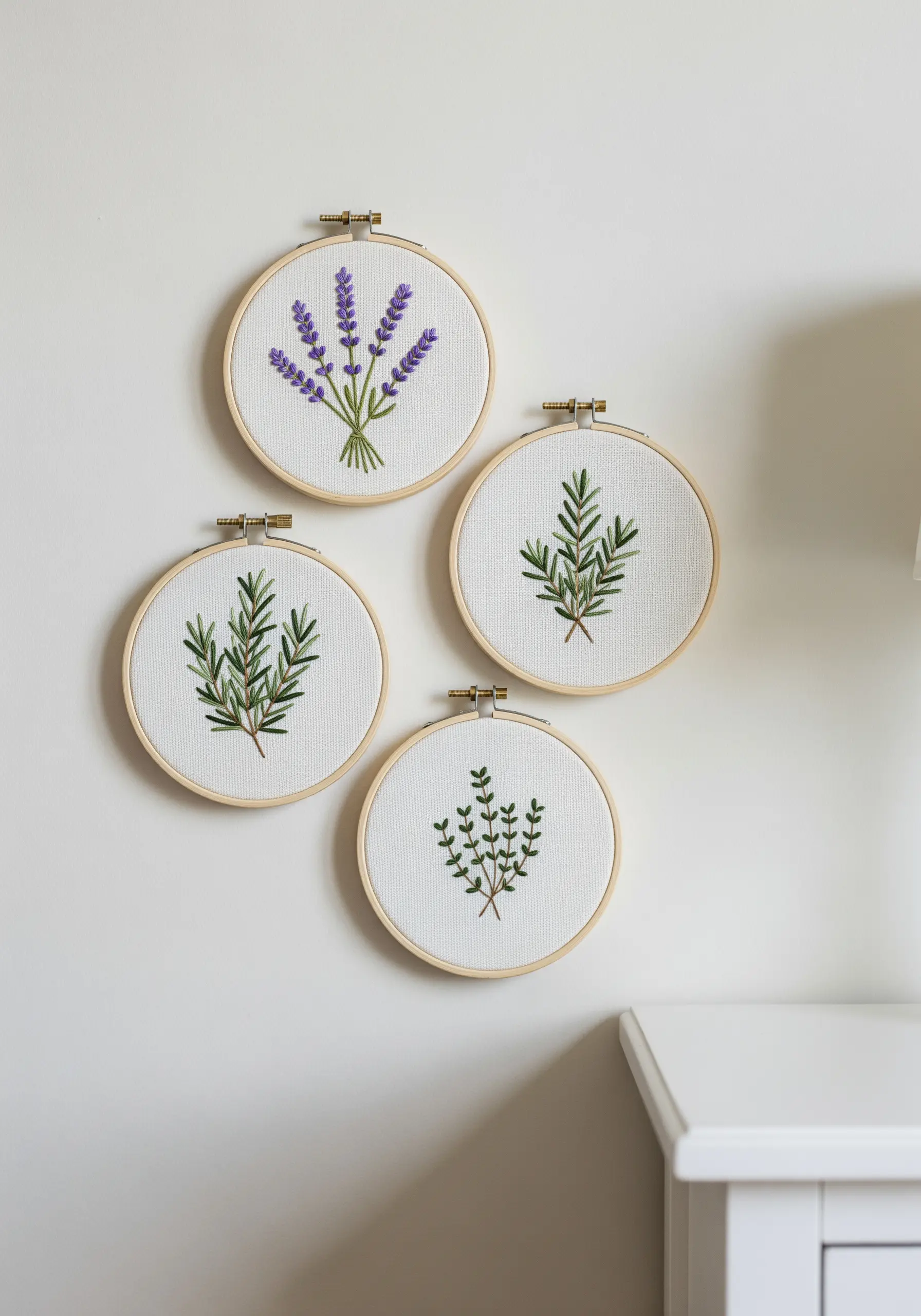 Four small embroidery hoops with lavender, rosemary, and thyme motifs.