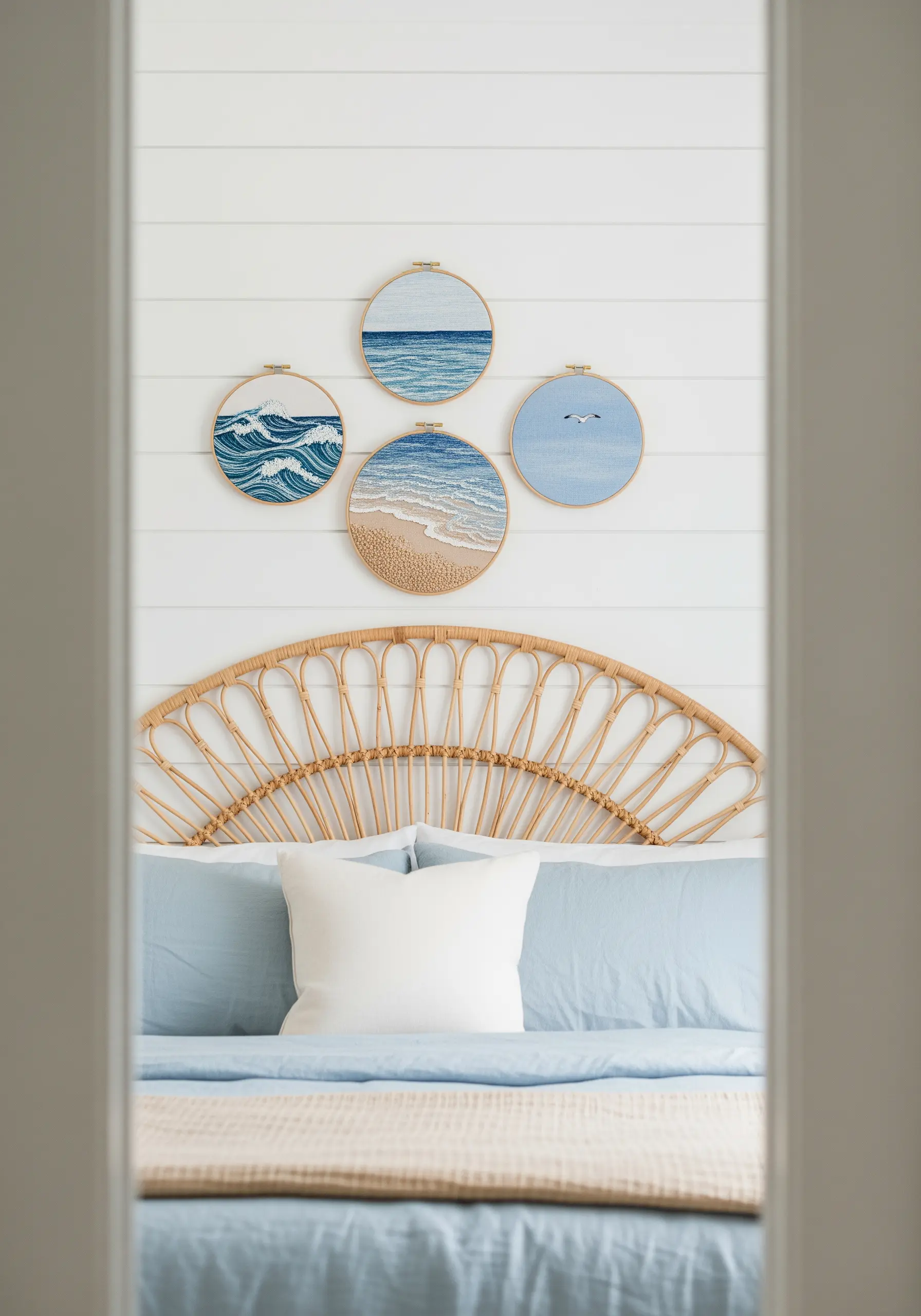 A gallery wall of four embroidery hoops depicting different ocean and beach scenes.