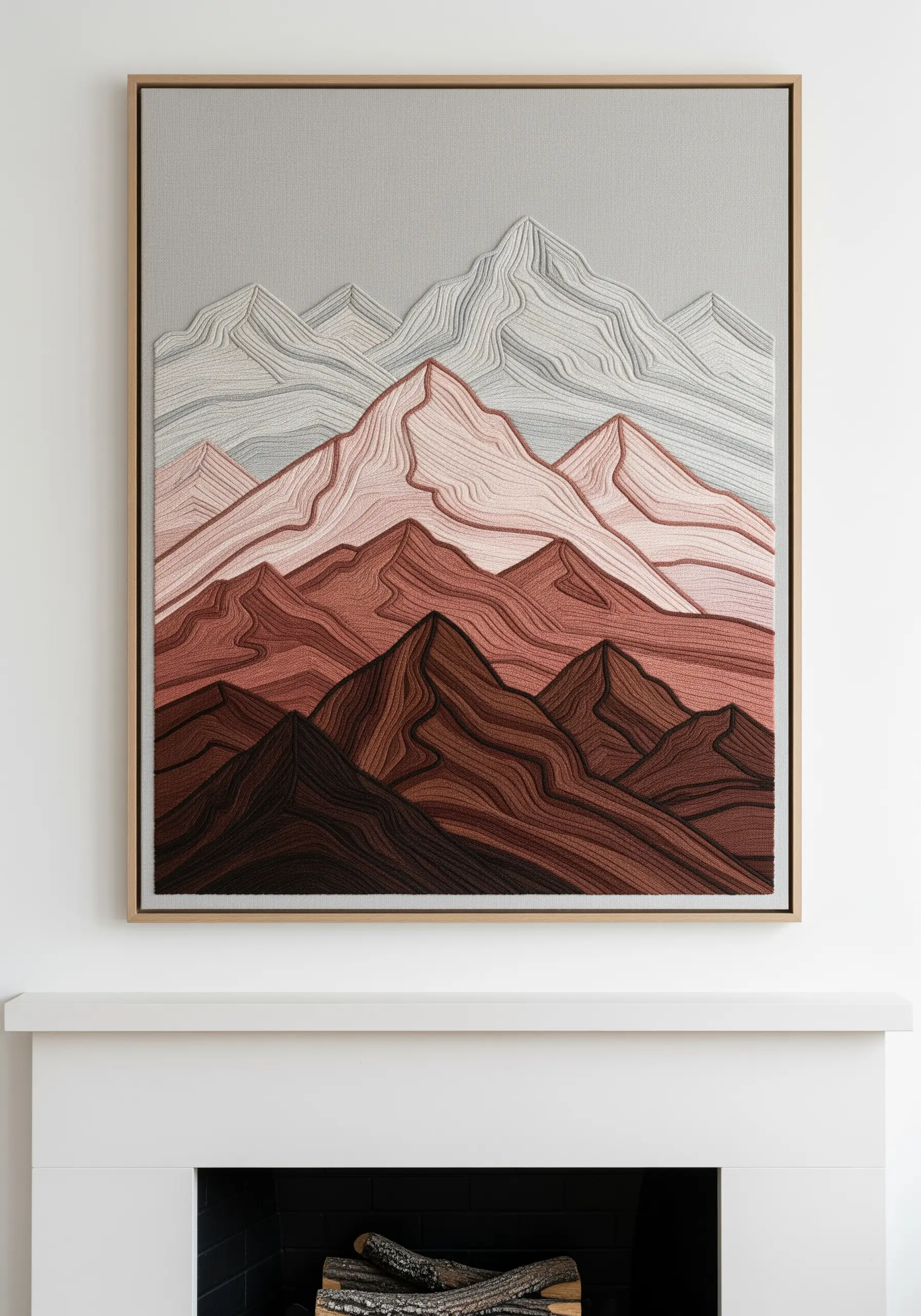 Framed embroidery of a mountain range with layers of terracotta, pink, and brown thread.
