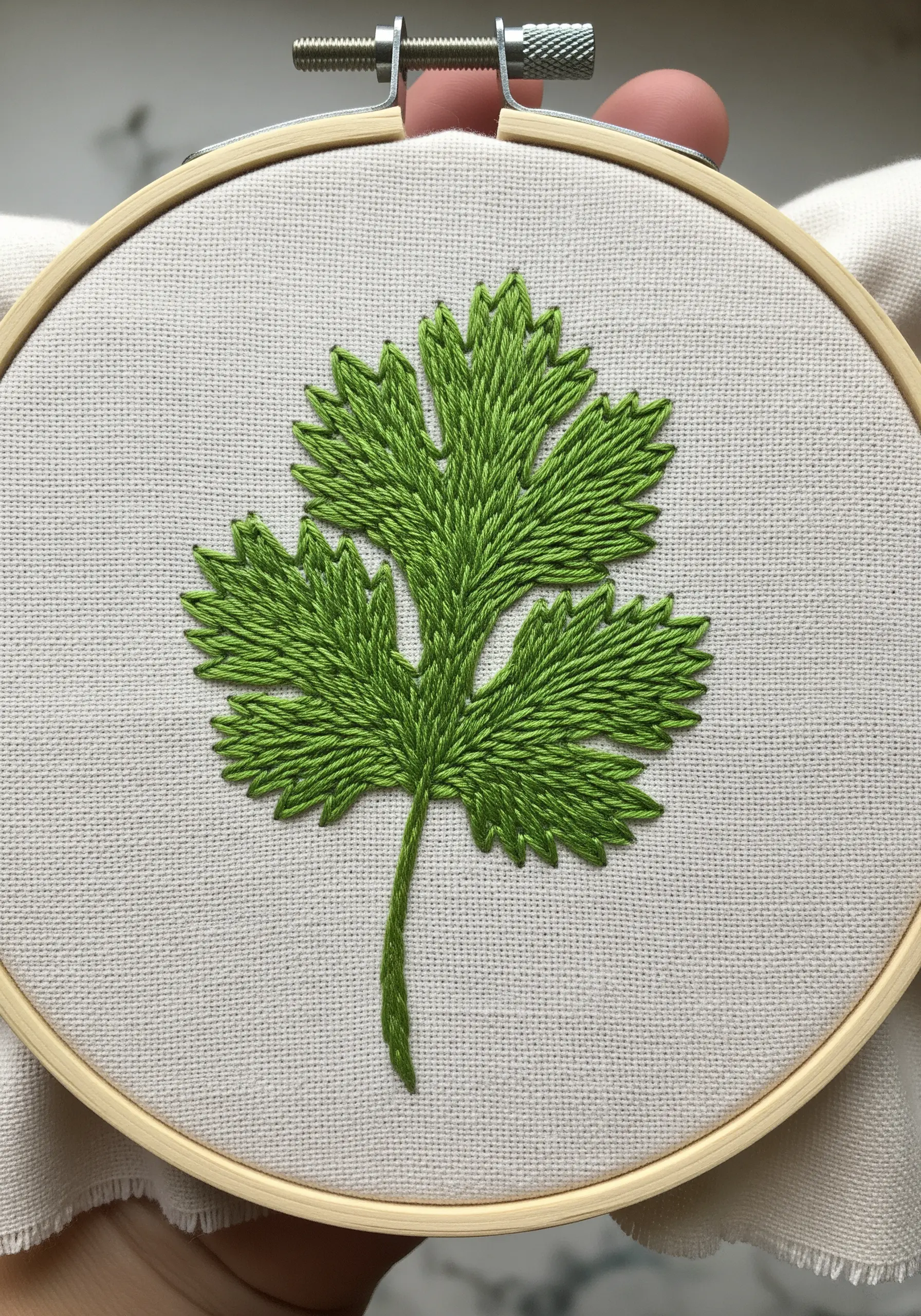 A perfectly embroidered cilantro leaf with exceptionally clean satin-stitched edges.