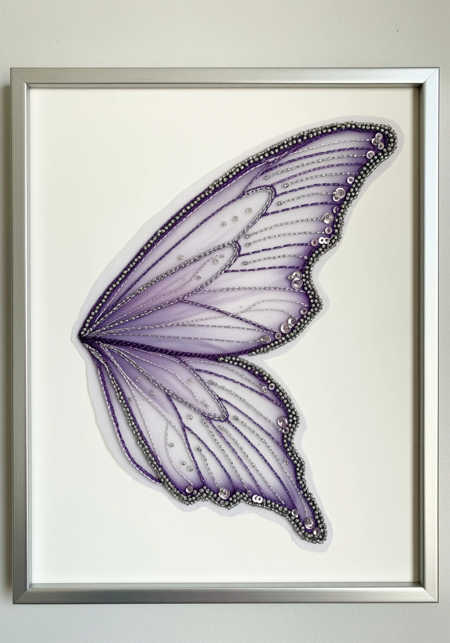 A delicate, translucent butterfly wing created with beads and sequins on organza.