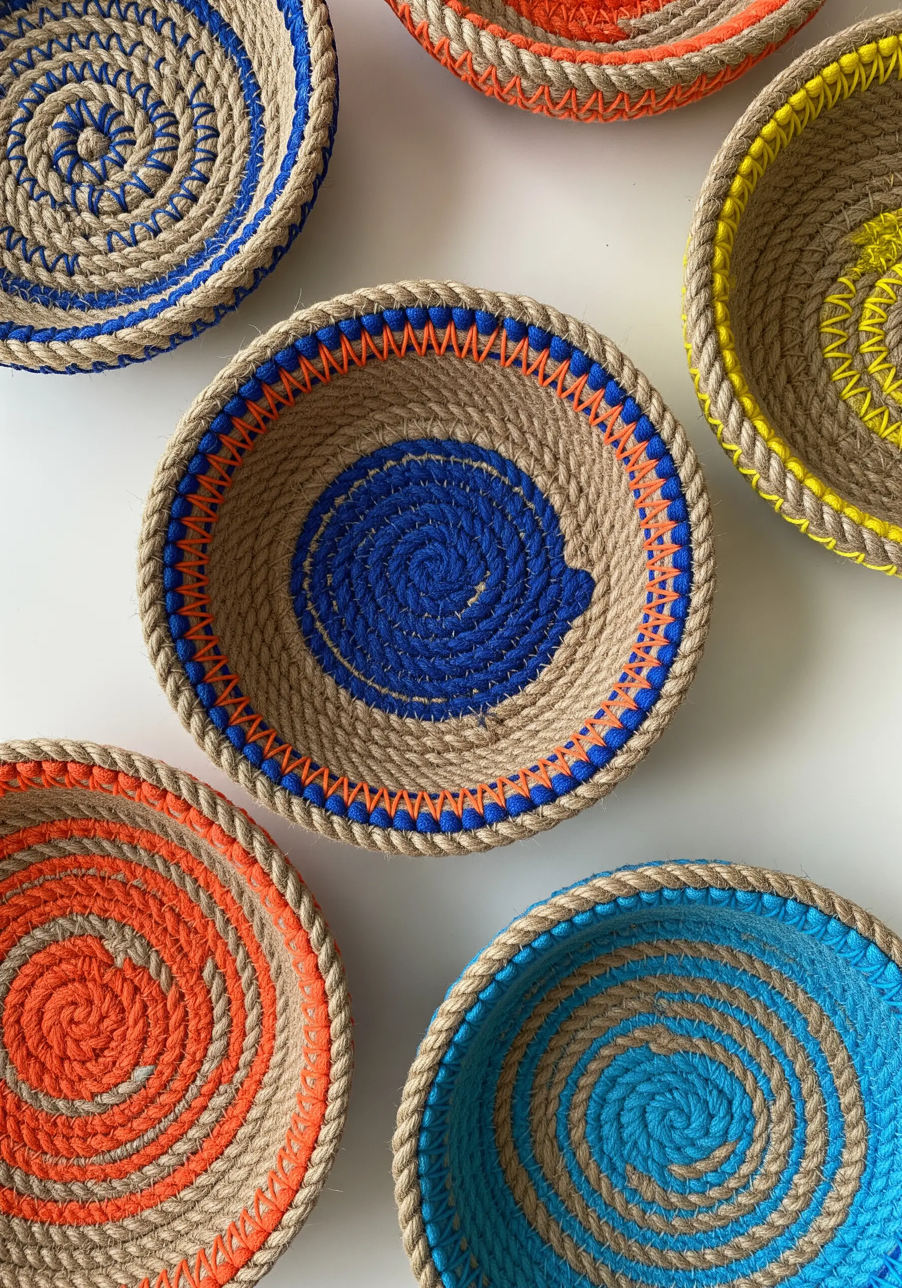 Colorful coiled rope bowls decorated with bright embroidery floss wrapping.