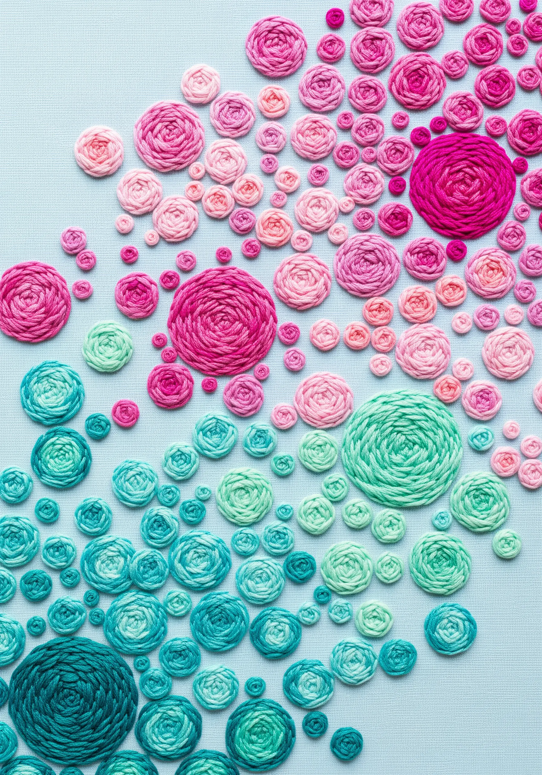 A dense pattern of woven wheel roses in shades of pink, magenta, and turquoise.