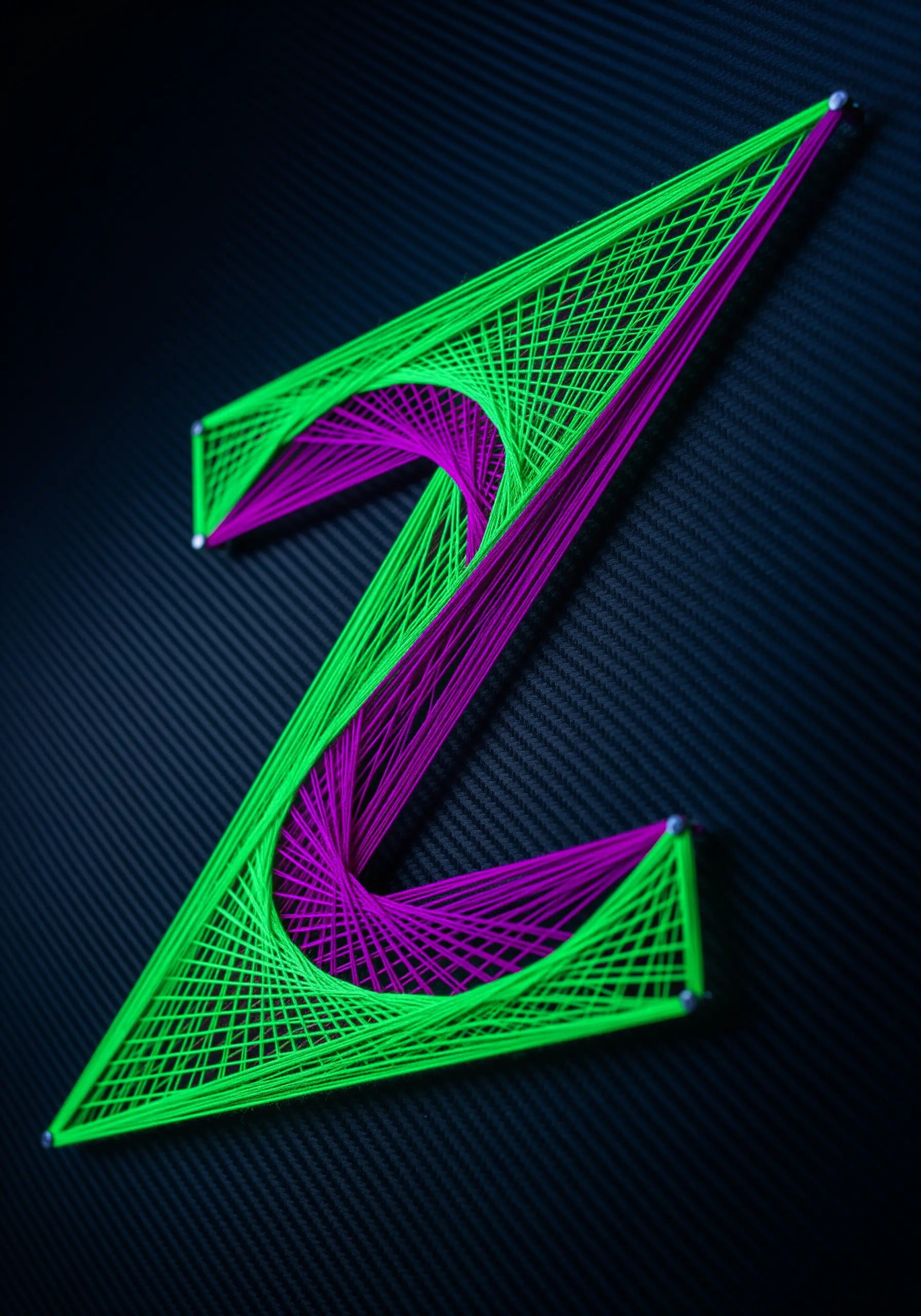 A geometric letter 'Z' created with intersecting lines of bright green and purple neon thread.