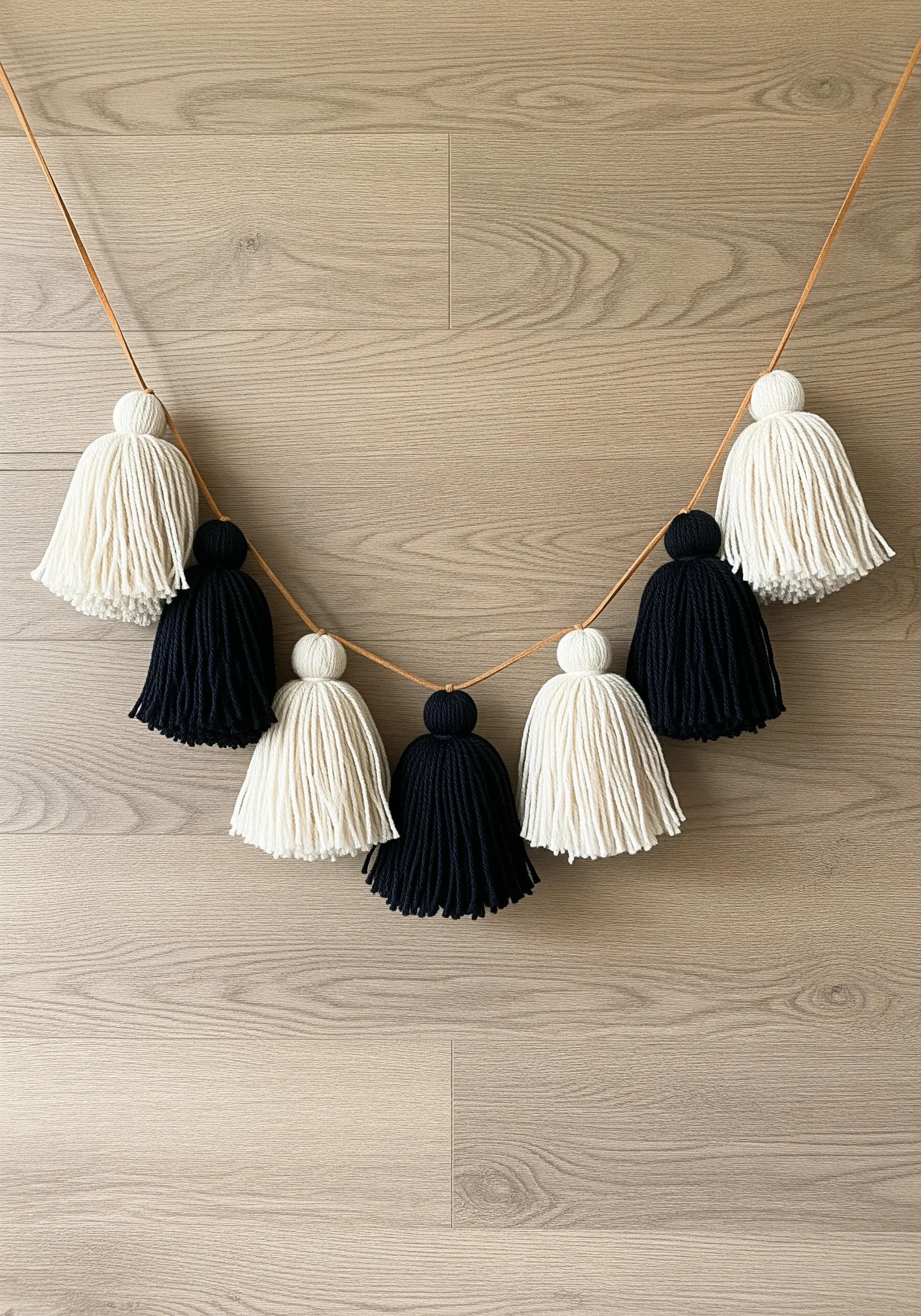 A garland of perfectly trimmed, alternating black and white yarn tassels.