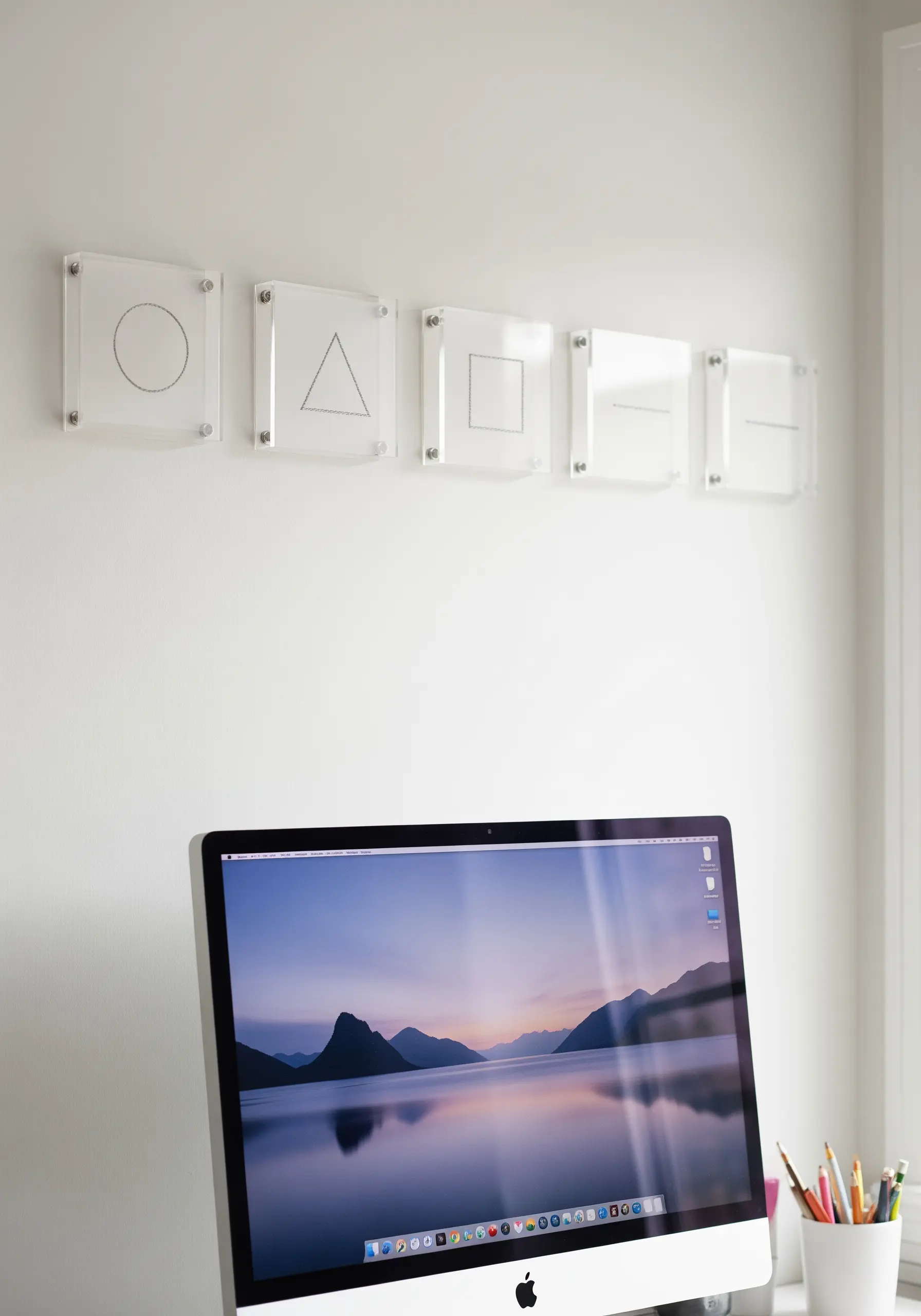A series of simple geometric shapes stitched on sheer fabric and mounted in floating acrylic frames.