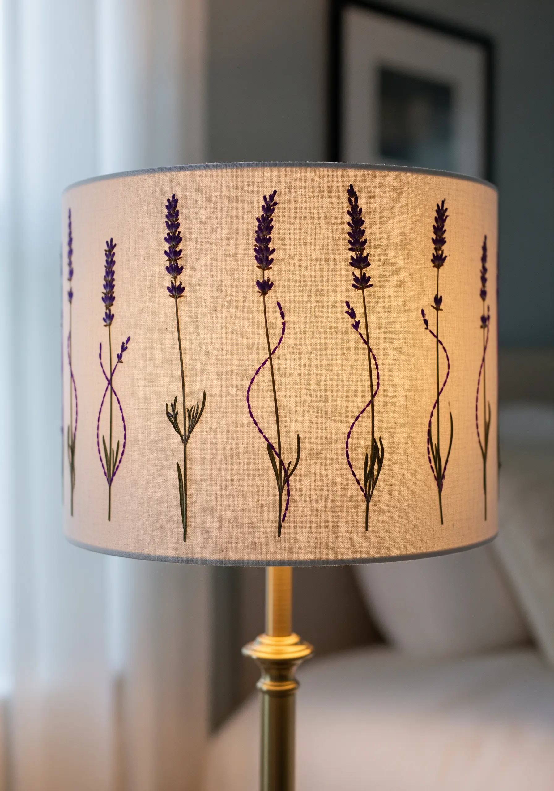 Pressed lavender and purple embroidery on a fabric lampshade, illuminated from within.
