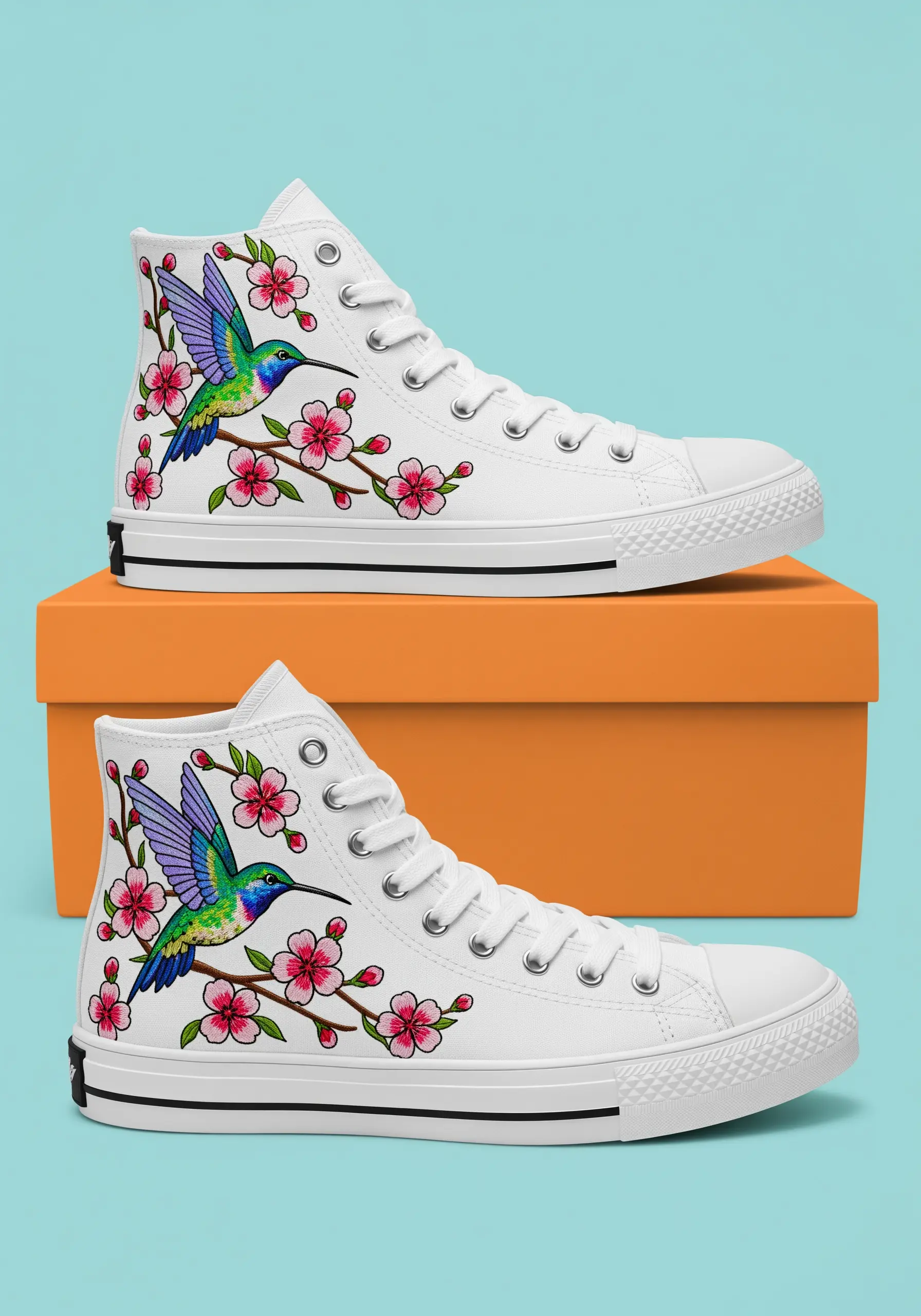 White high-top sneakers with a colorful embroidered hummingbird and cherry blossoms.