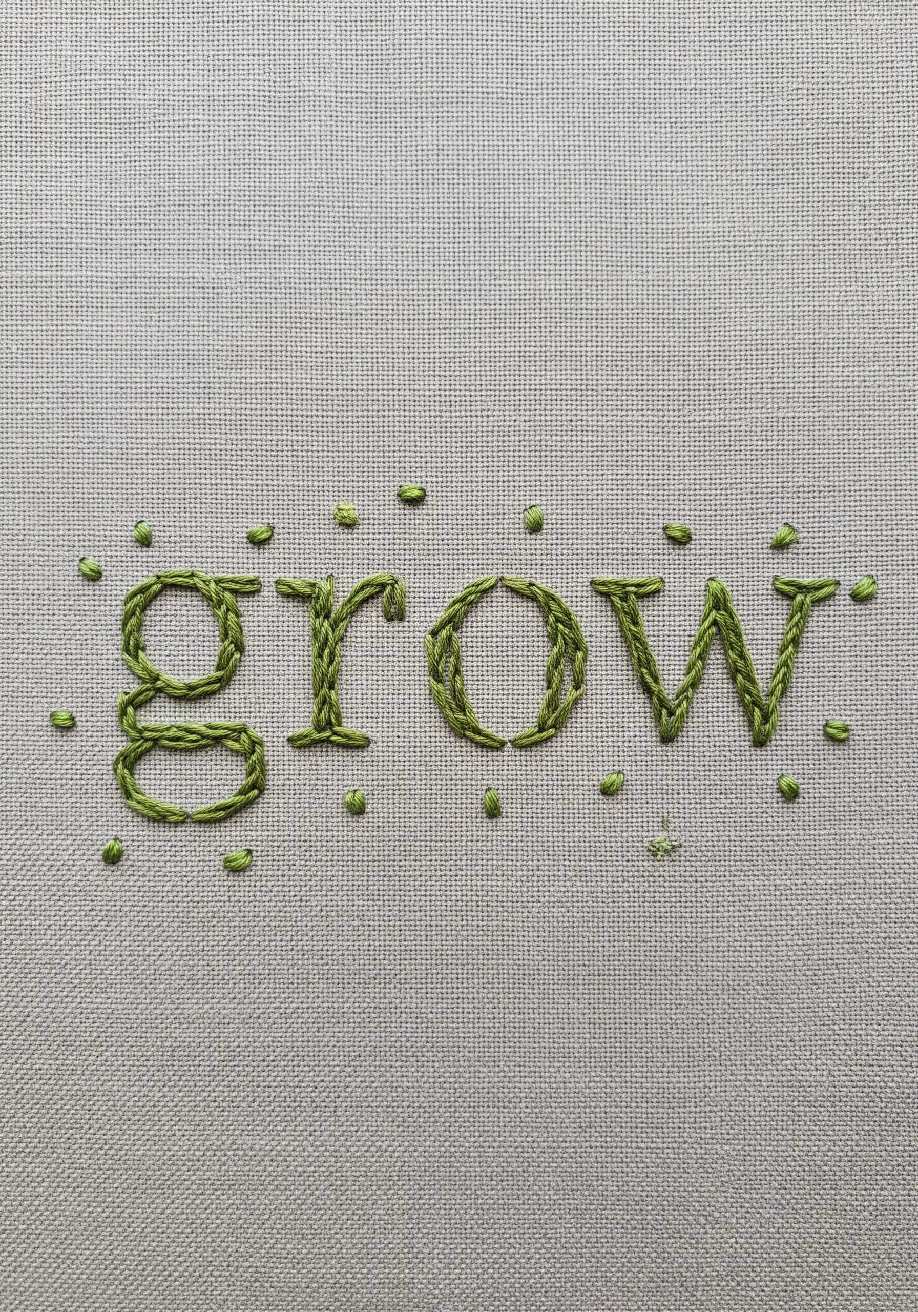 The word 'grow' in a leafy green stitch with scattered seed stitches.